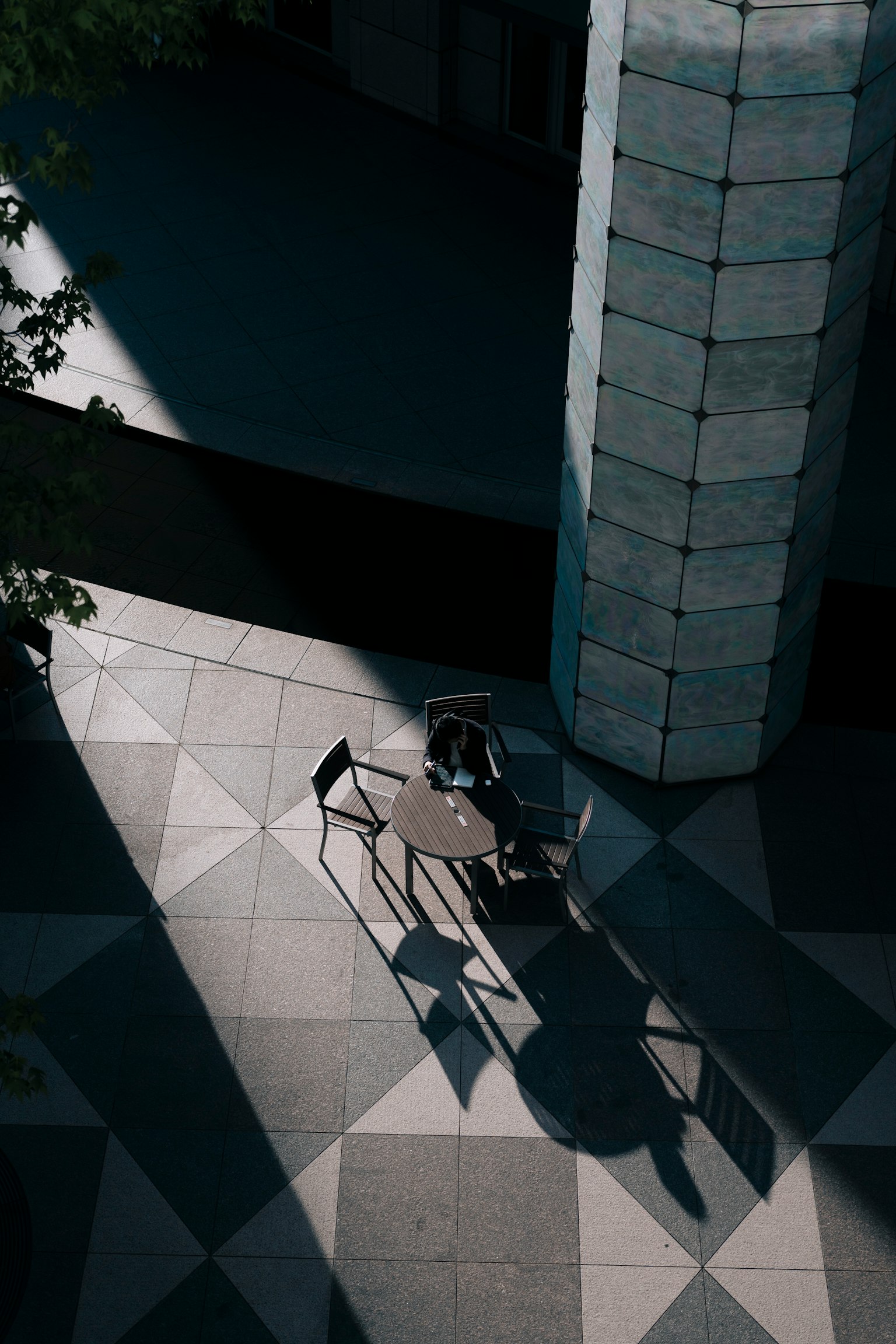 Modern outdoor space with a table and chairs casting shadows