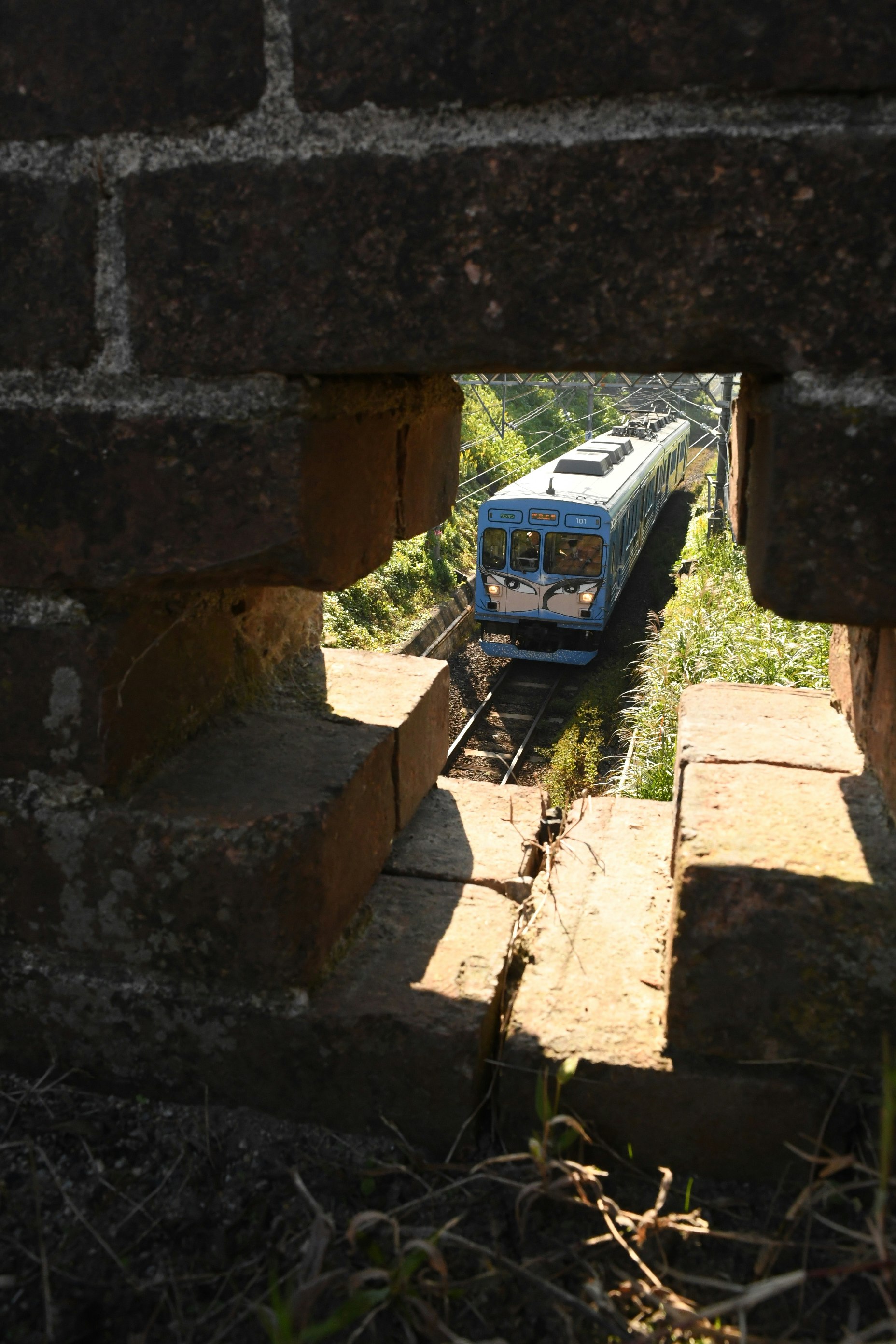 Tren ninja pasando bajo un antiguo puente de ladrillo