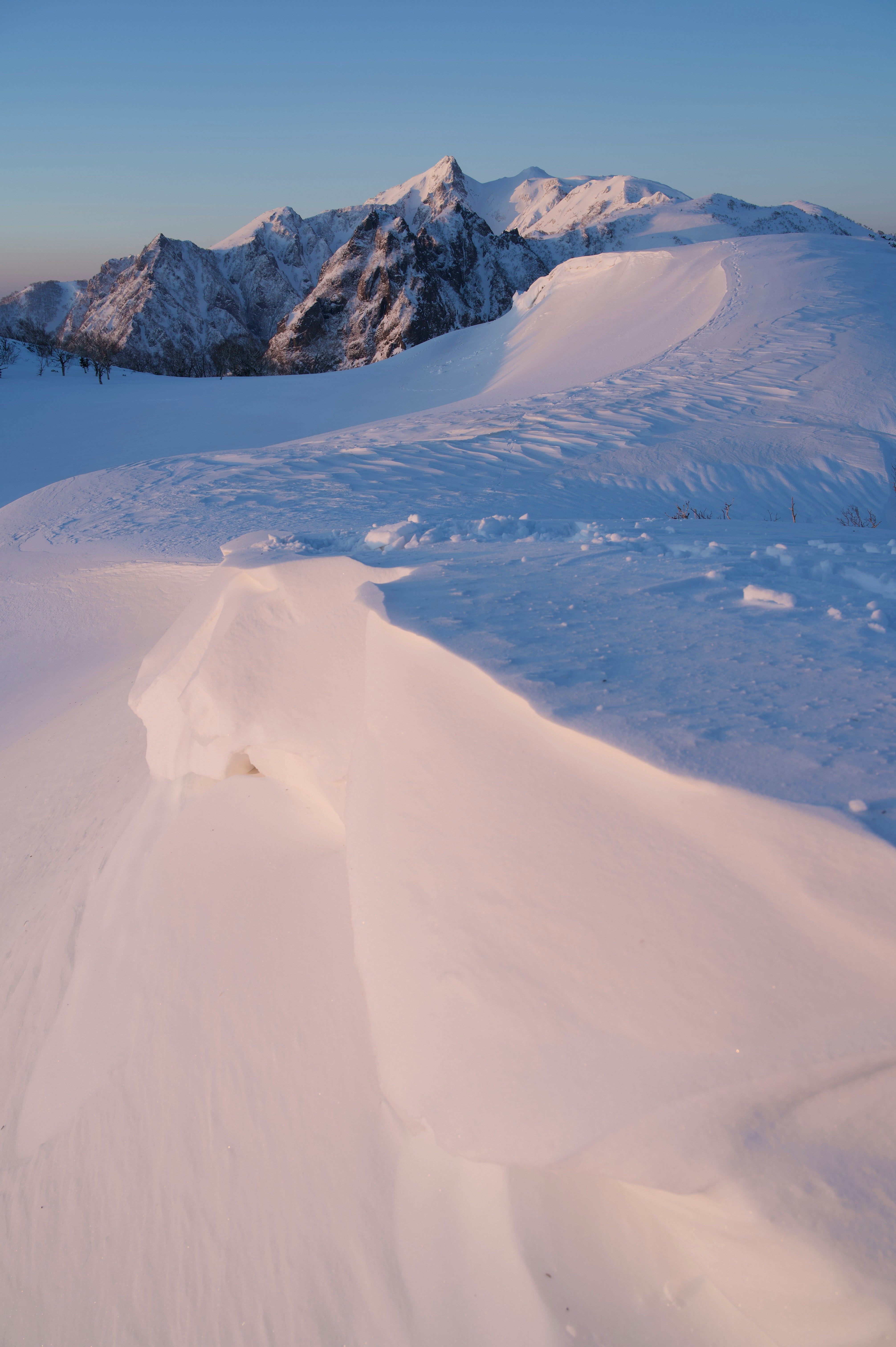 雪原を走るトレイルと山並みの風景