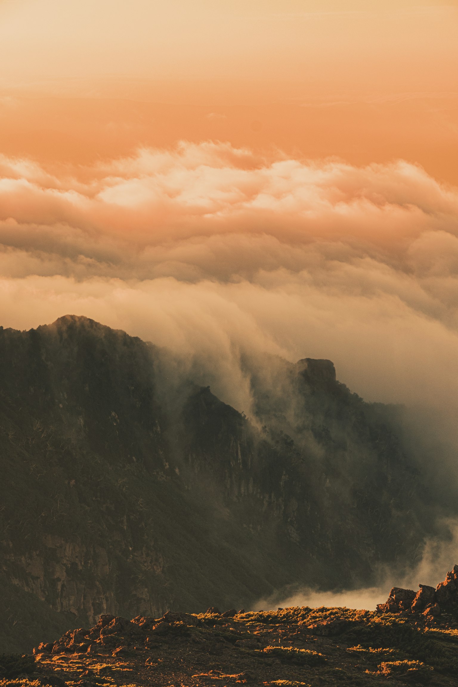 Paisaje montañoso envuelto en nubes al atardecer
