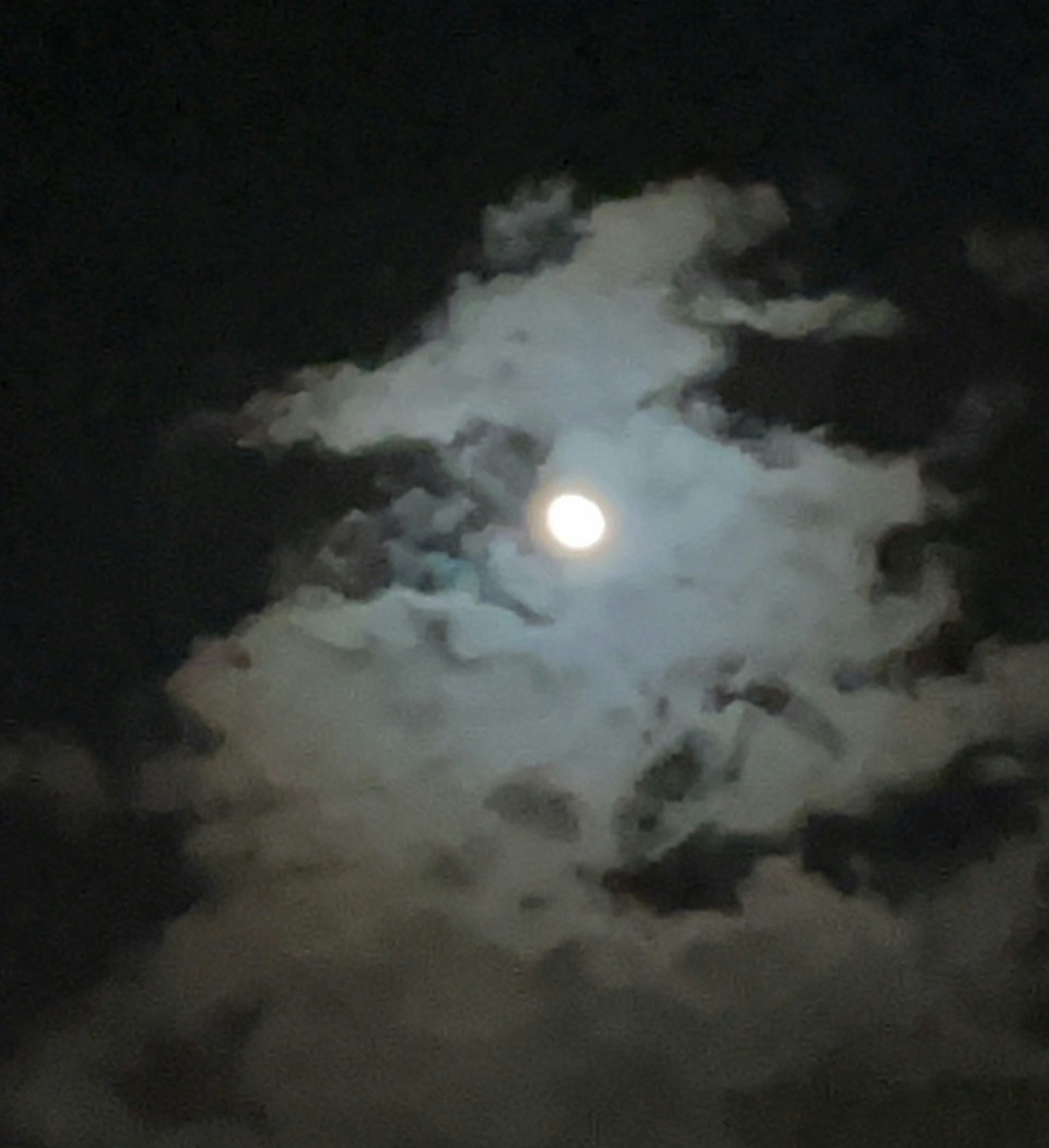 黑暗夜空中被云彩环绕的明亮月亮