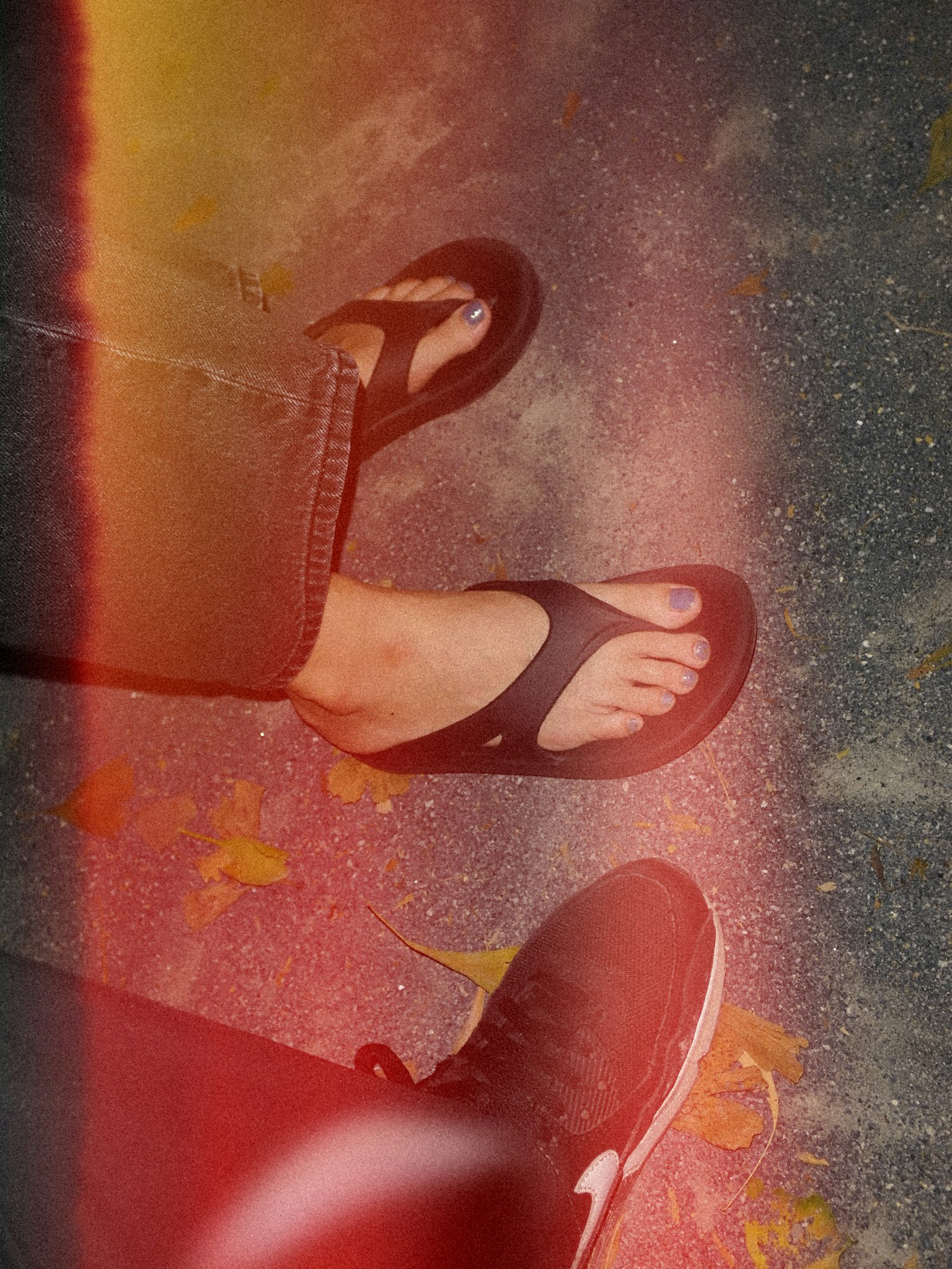 Gros plan sur des pieds portant des tongs et des baskets avec un effet de filtre coloré