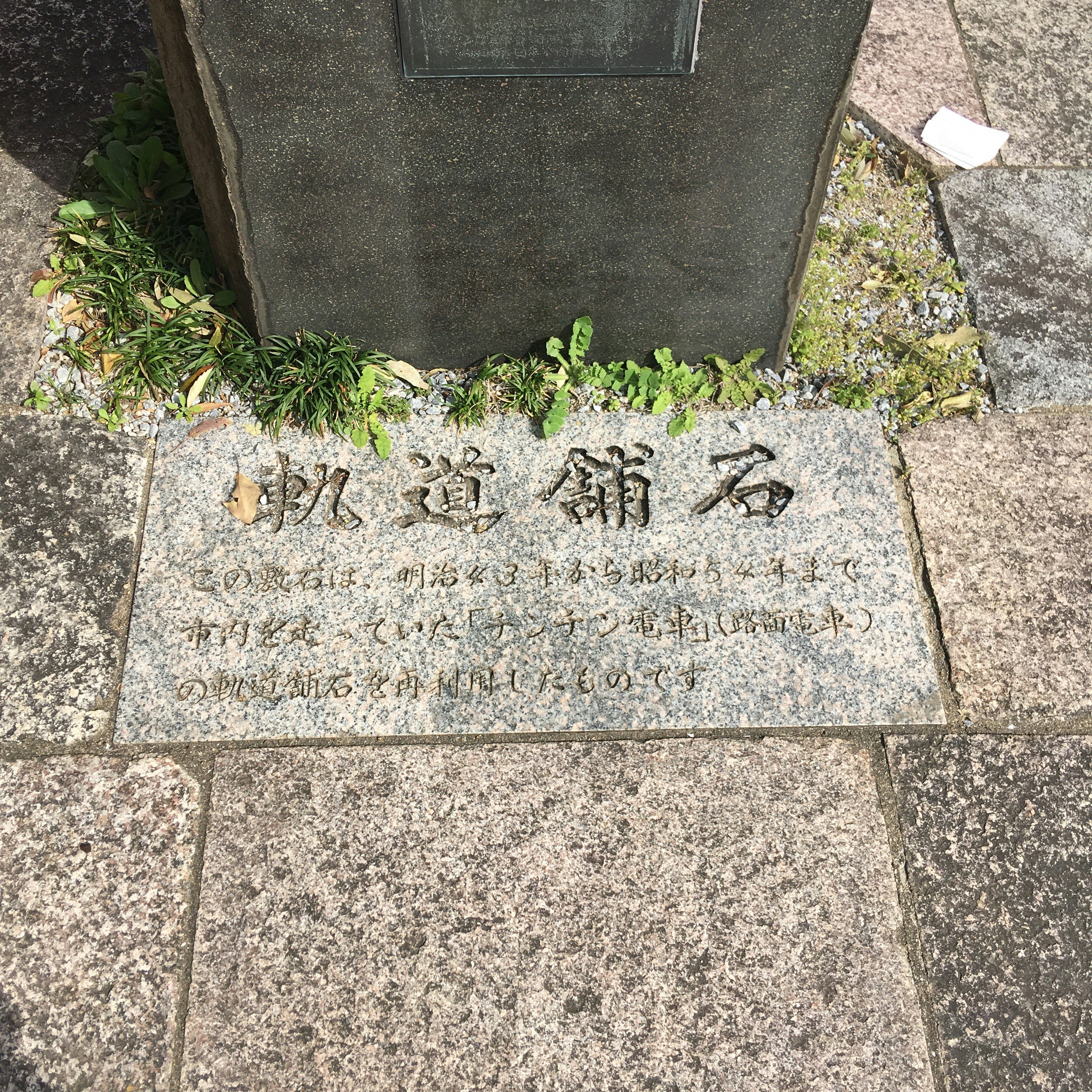 石碑の文字が刻まれた台座の足元
