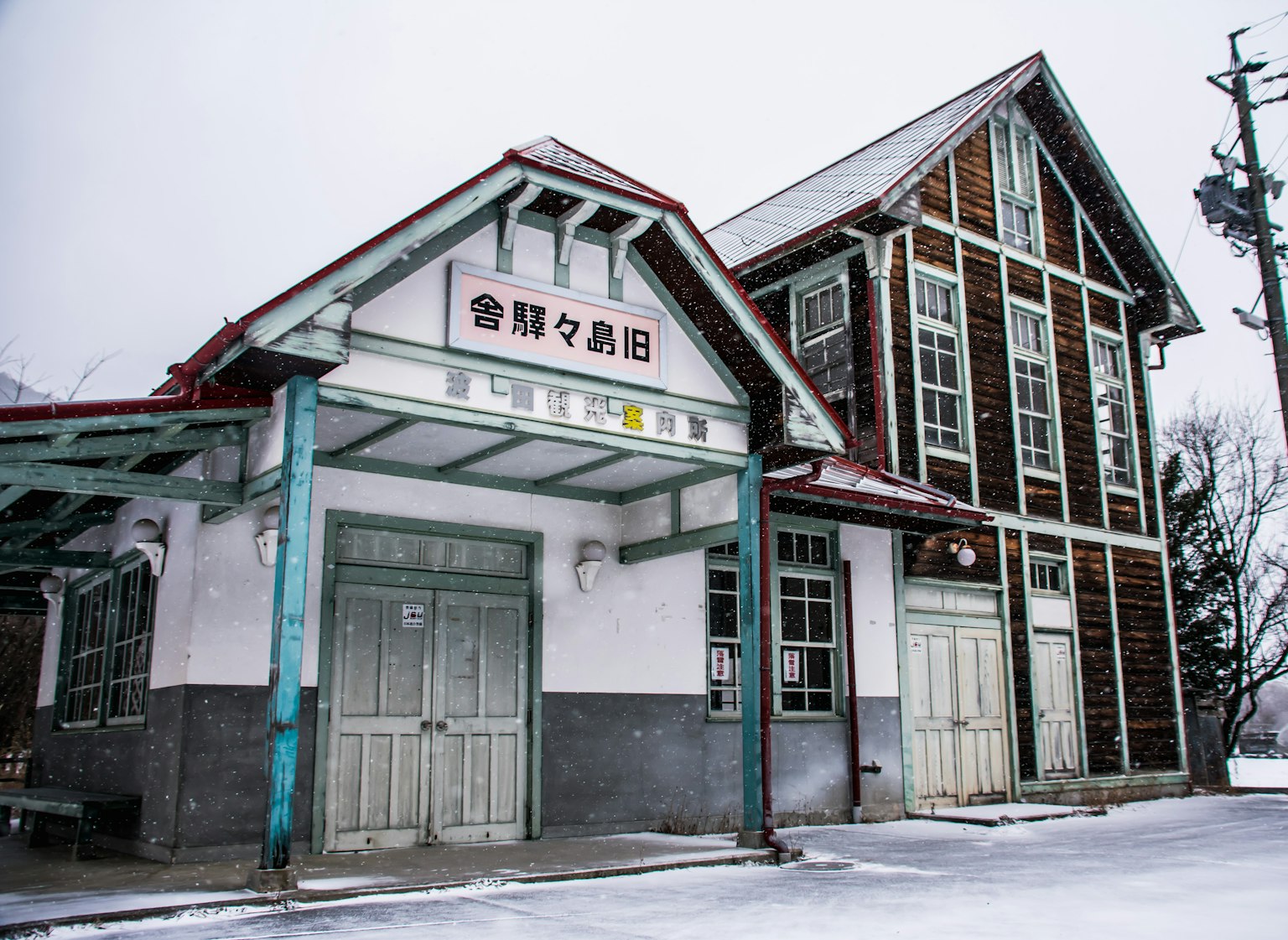 Extérieur d'une vieille gare recouverte de neige avec une structure en bois et un design traditionnel