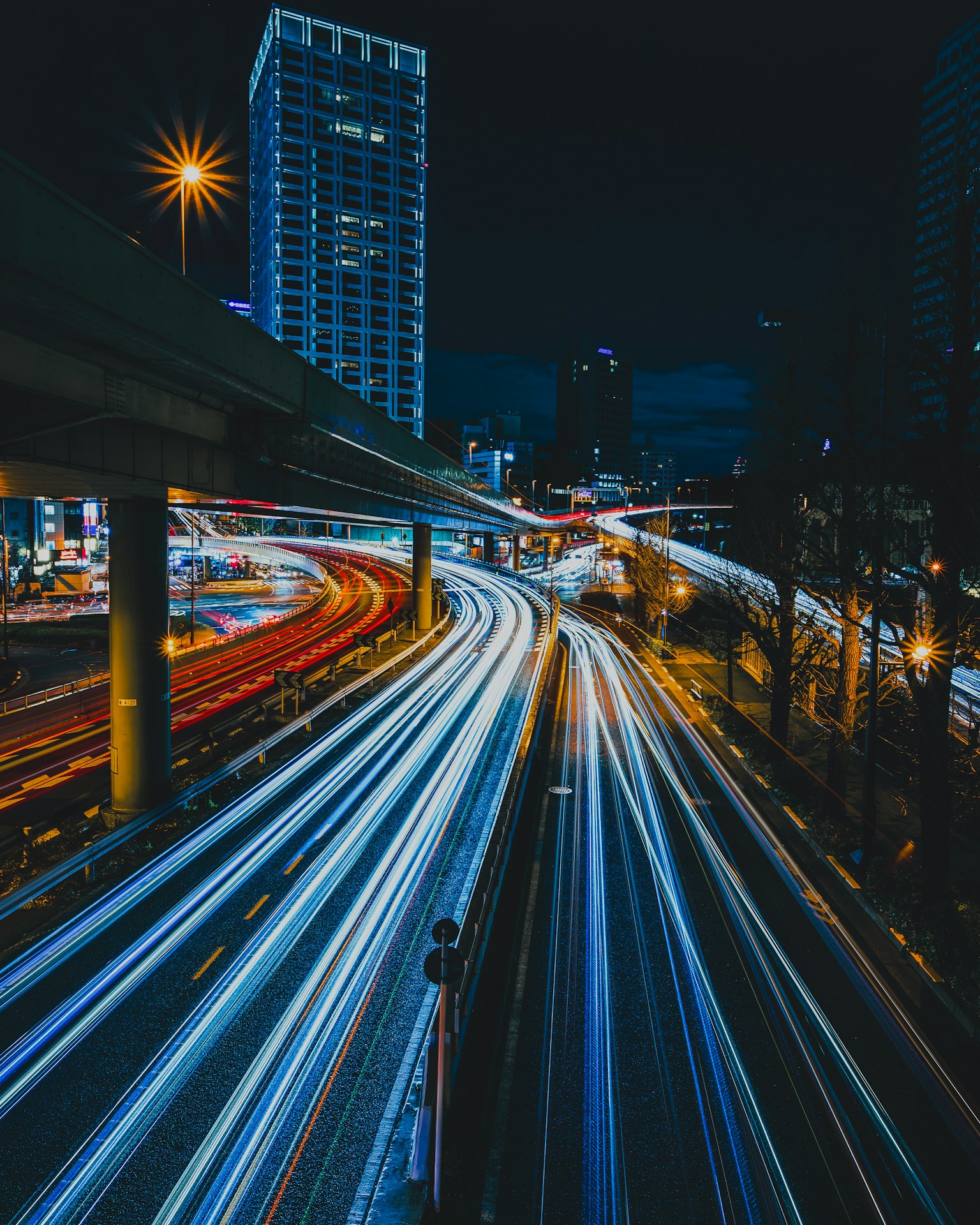 Night cityscape with light trails and skyscrapers