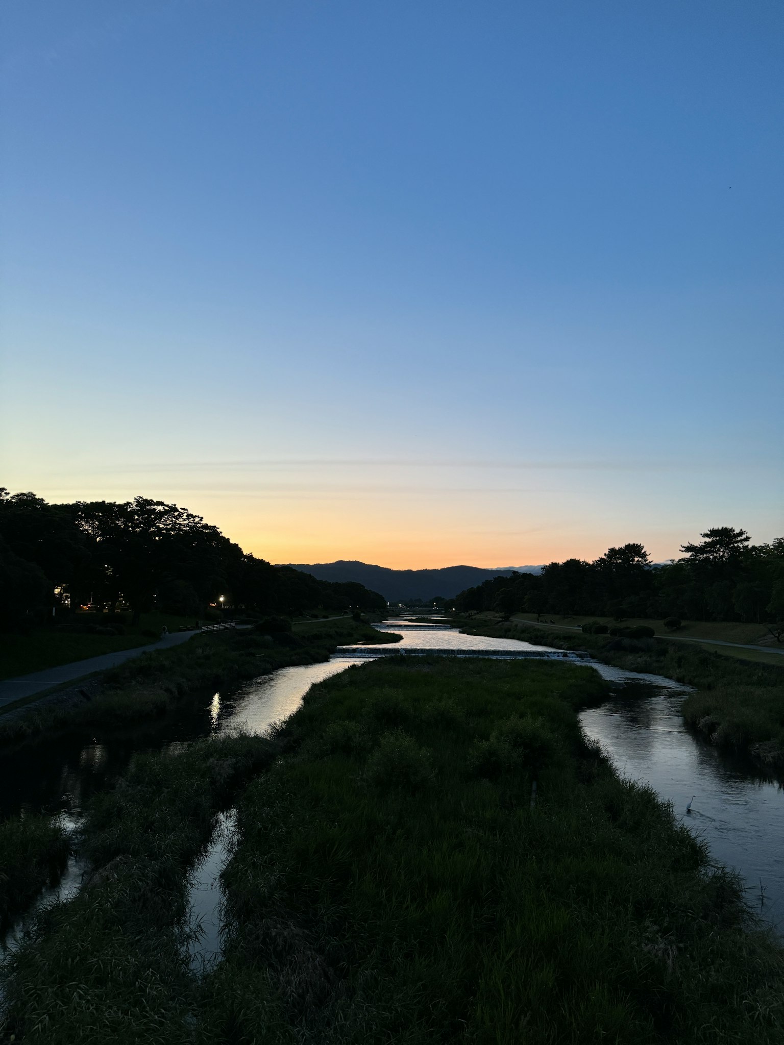 Fluss- und Wiesenlandschaft blauer Himmel und Farbverlauf des Sonnenuntergangs