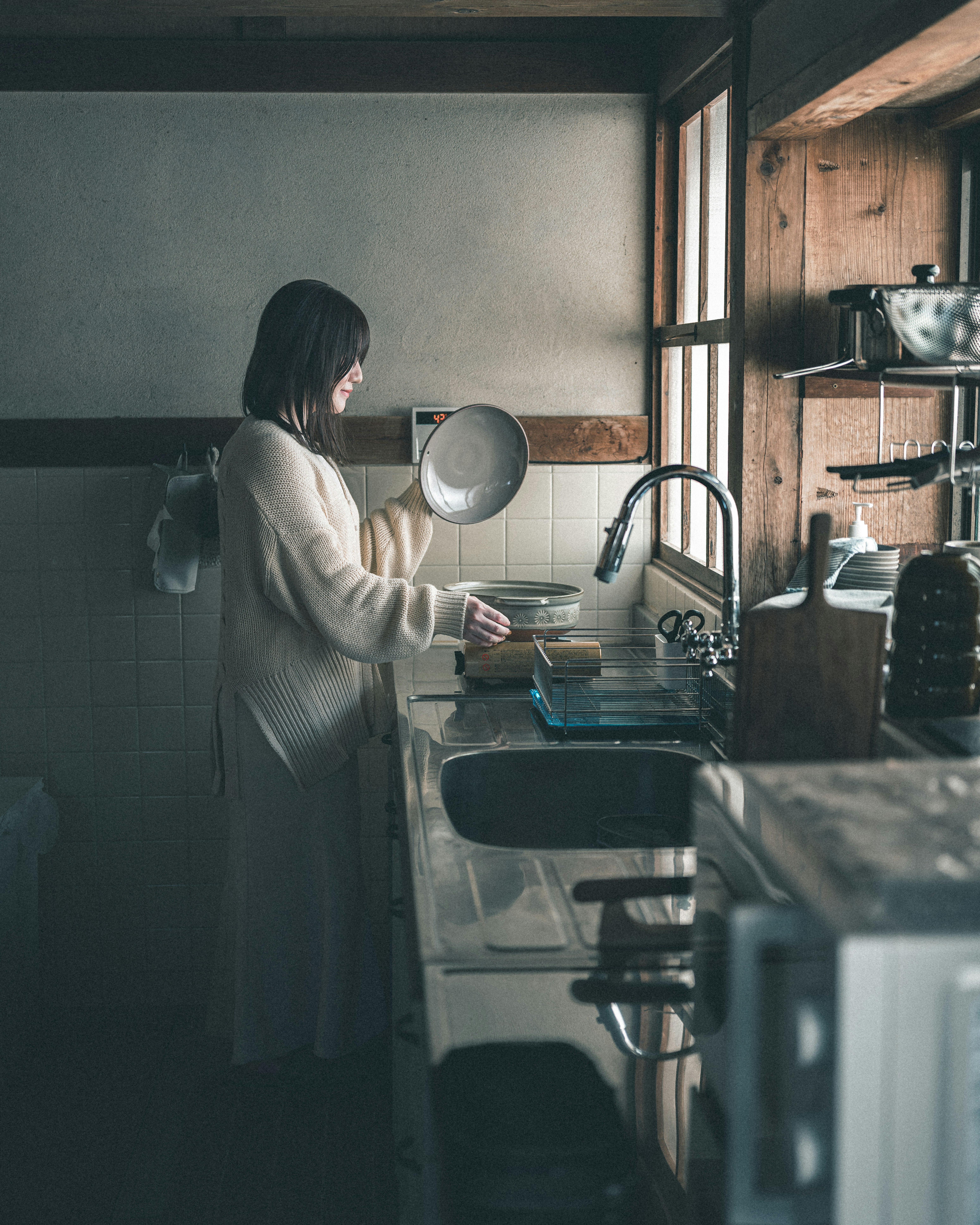 寝室の向こうのキッチンで料理する女性のいる朝の室内