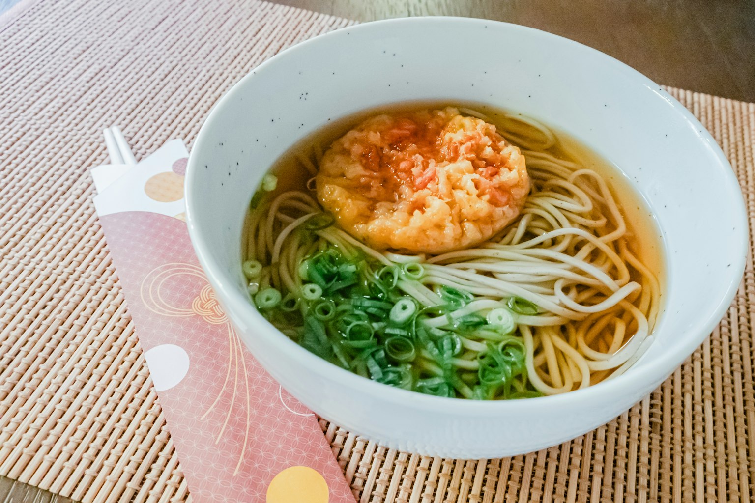 Bol de nouilles soba avec des oignons verts et un gâteau de crevettes