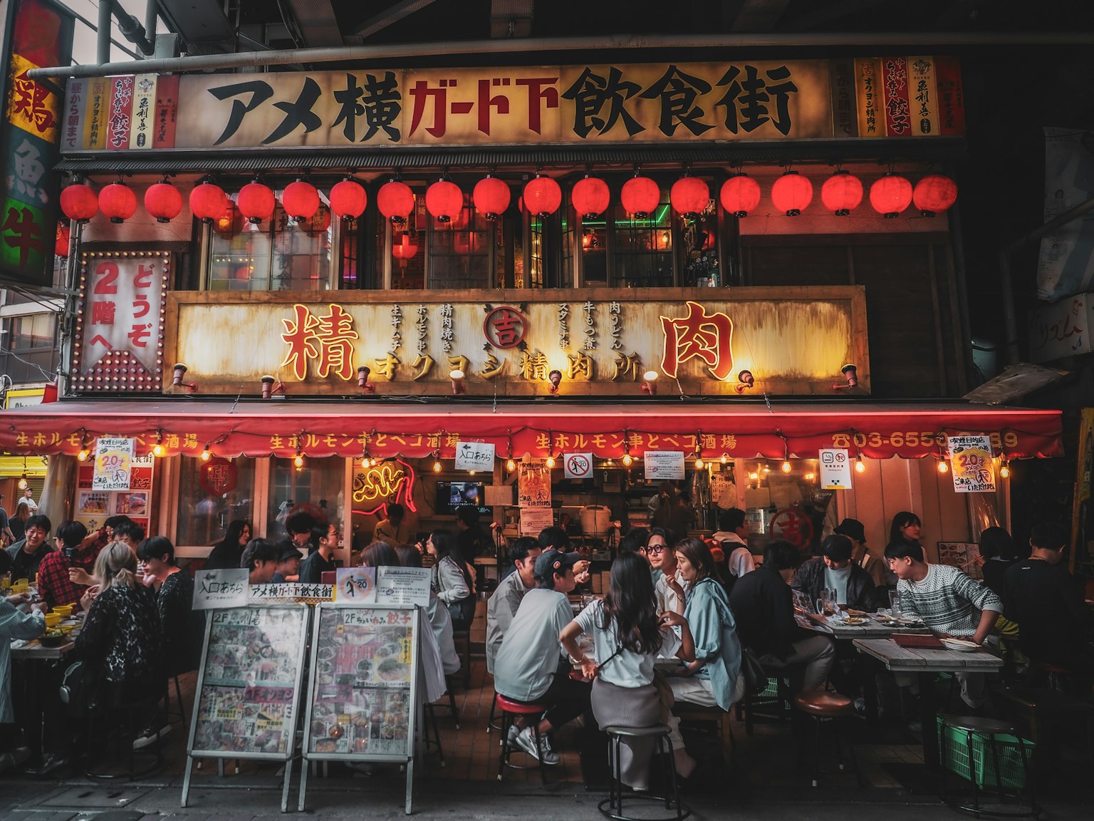 Scène de rue animée avec des lanternes rouges et des convives en foule