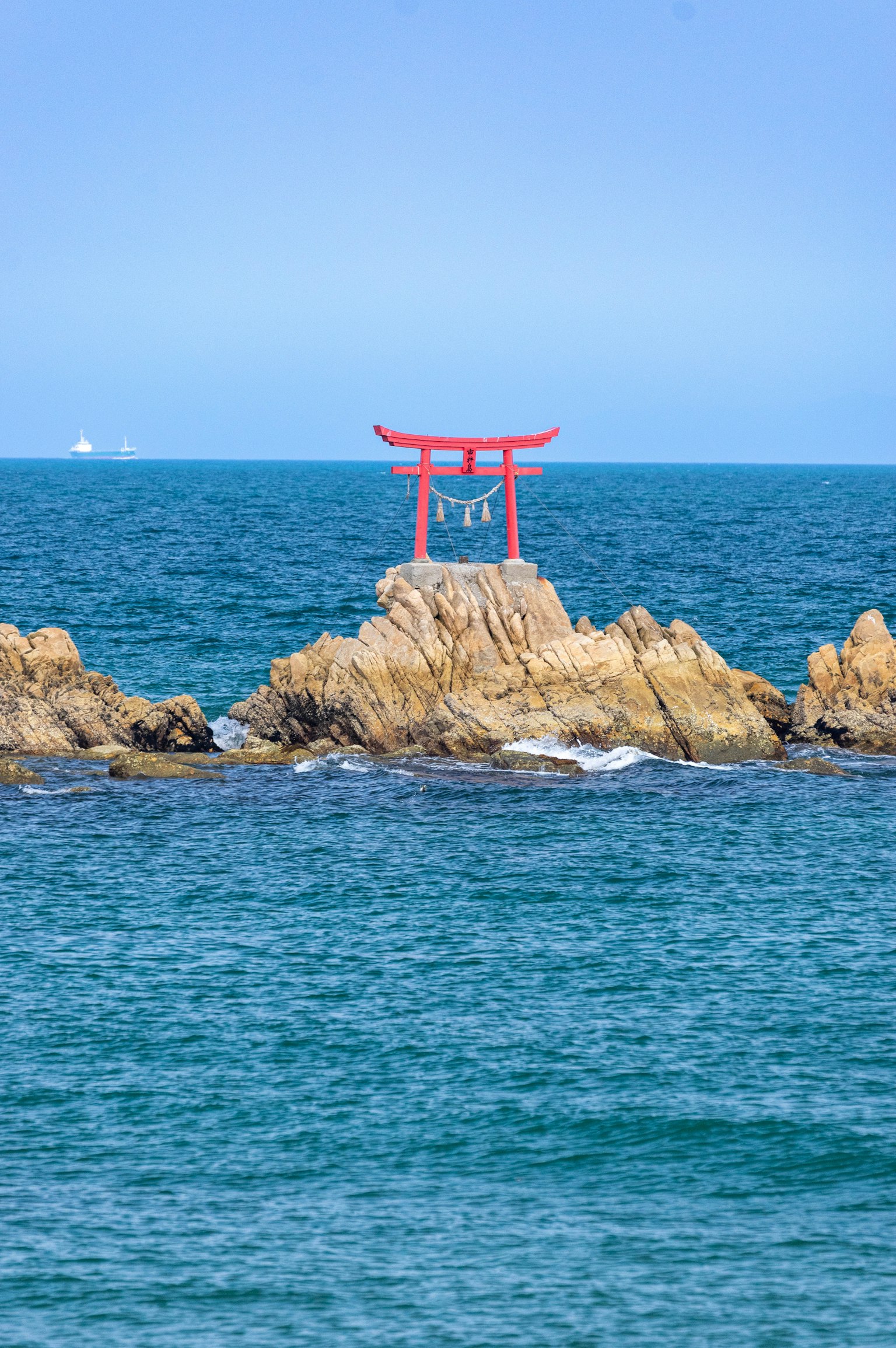 藍色海洋中的紅色鳥居和岩石