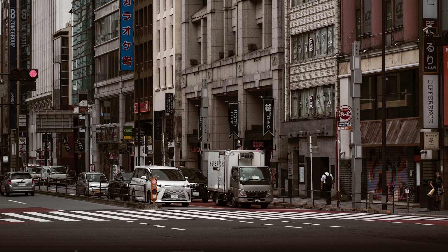 Urban street scene in Tokyo featuring vehicles at an intersection and buildings