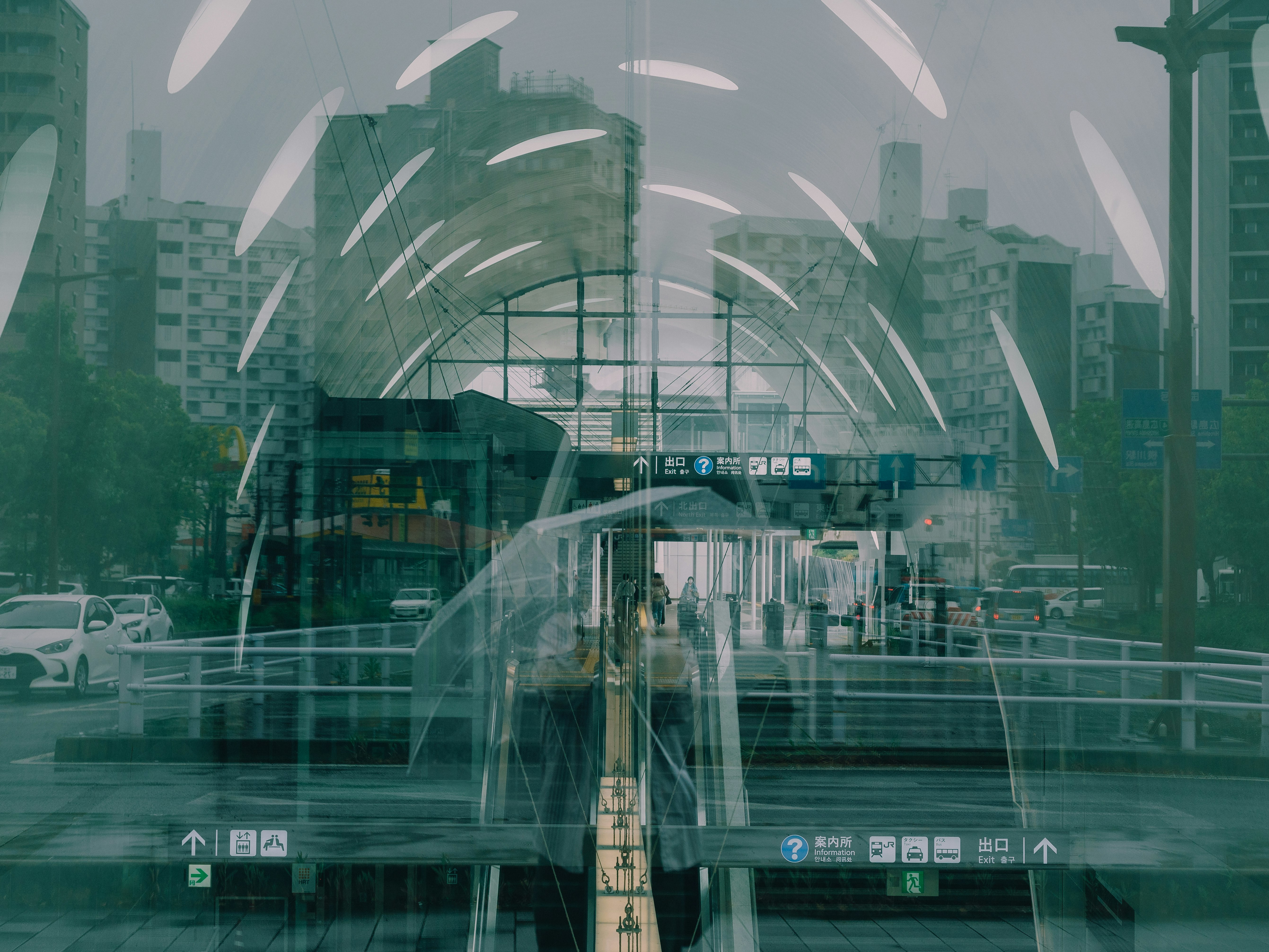 glass reflections over an elevated train station and city skyline