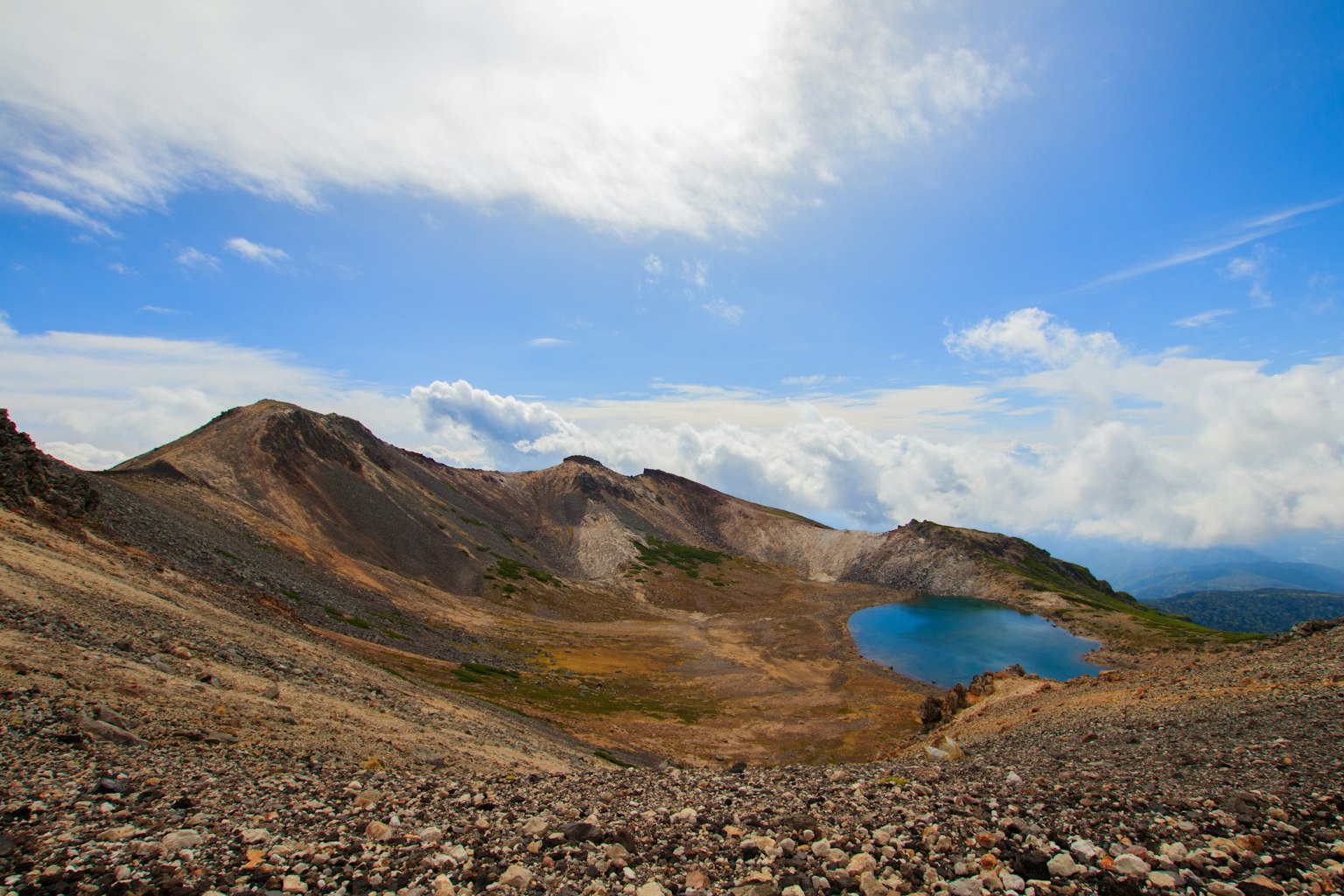 Vue pittoresque d'un lac bleu niché entre des montagnes sous un ciel partiellement nuageux