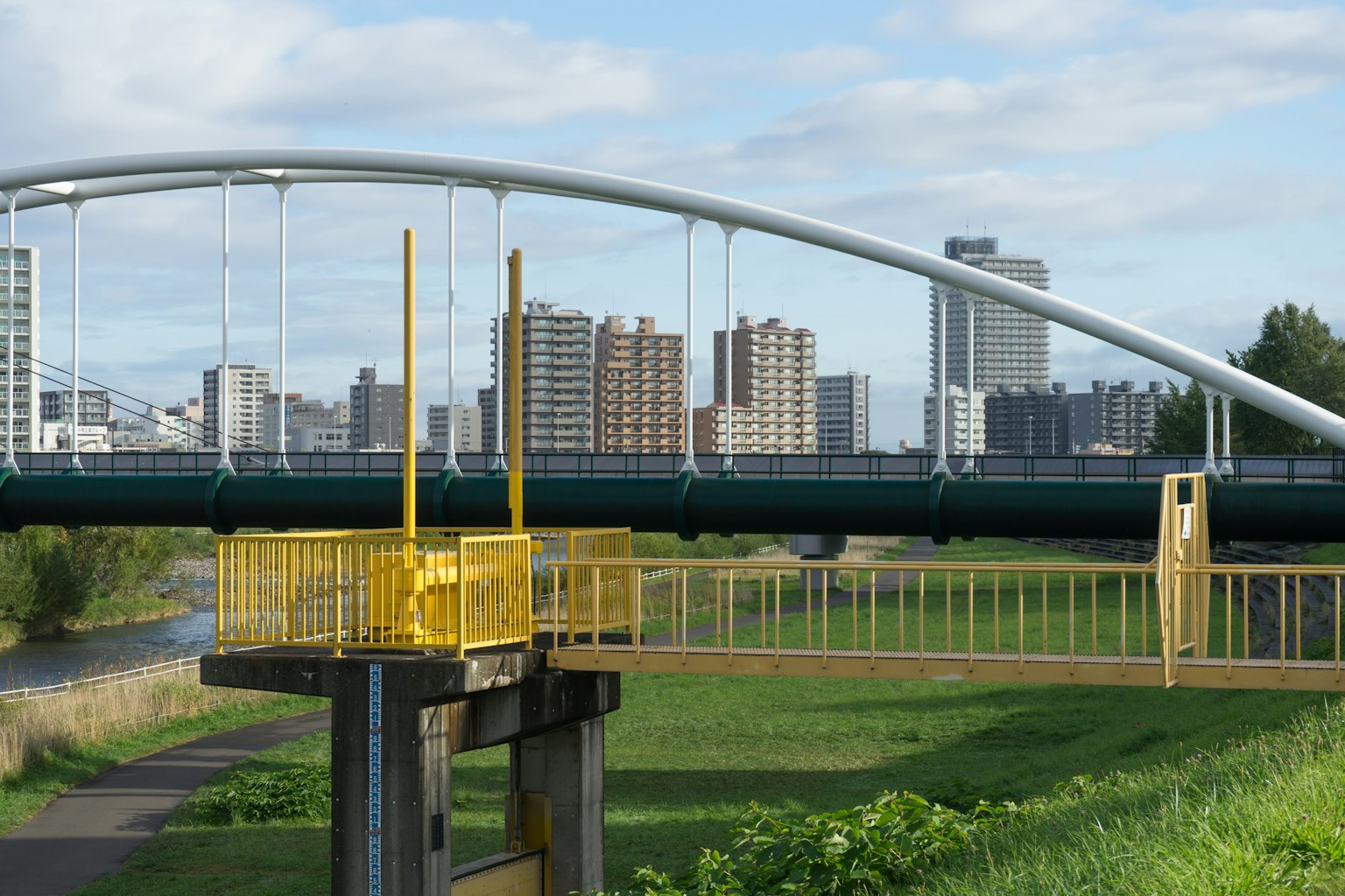 Moderner Bogenbrücke mit einer Stadtsilhouette im Hintergrund