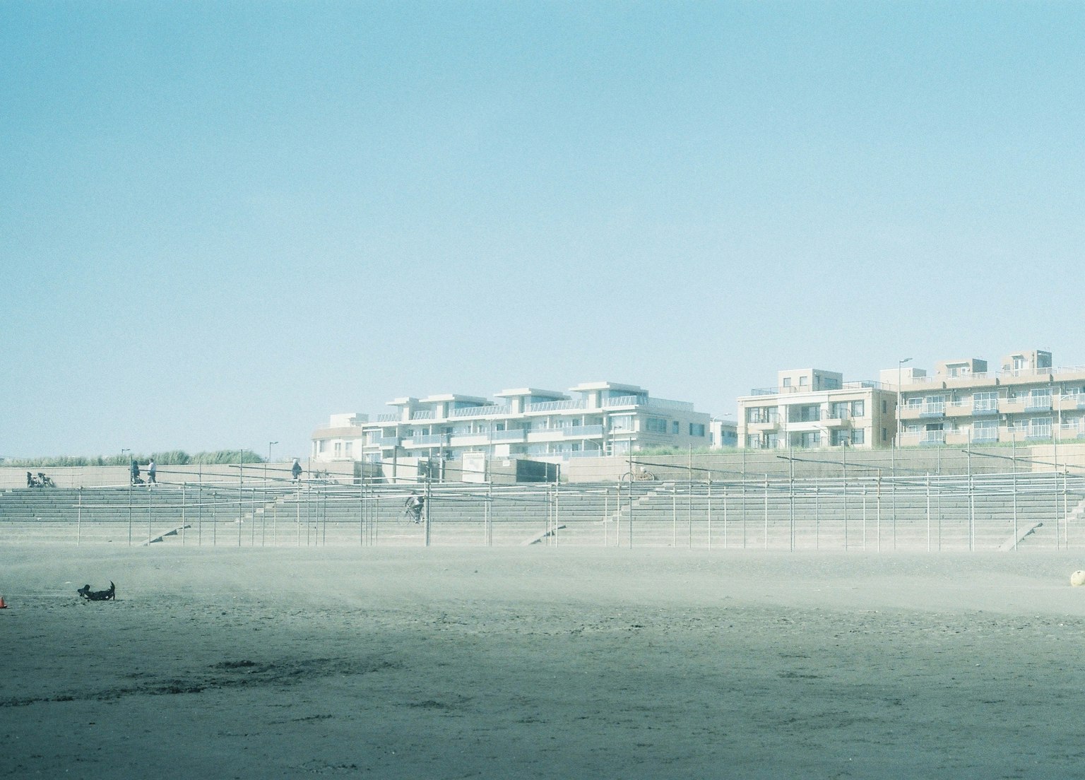 Beach scene with distant buildings under a blue sky