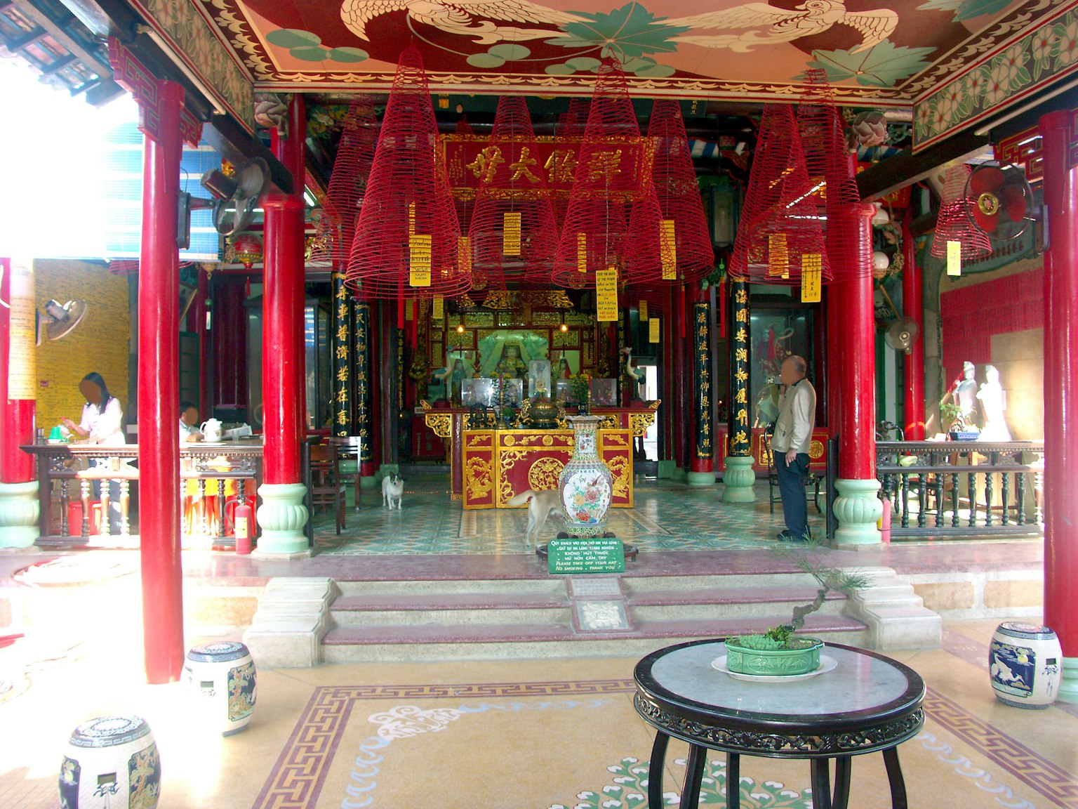 ภายในวัดจีนที่มีสีสันสดใสมีเสาหมายเลขแดงและการตกแต่งที่ซับซ้อน