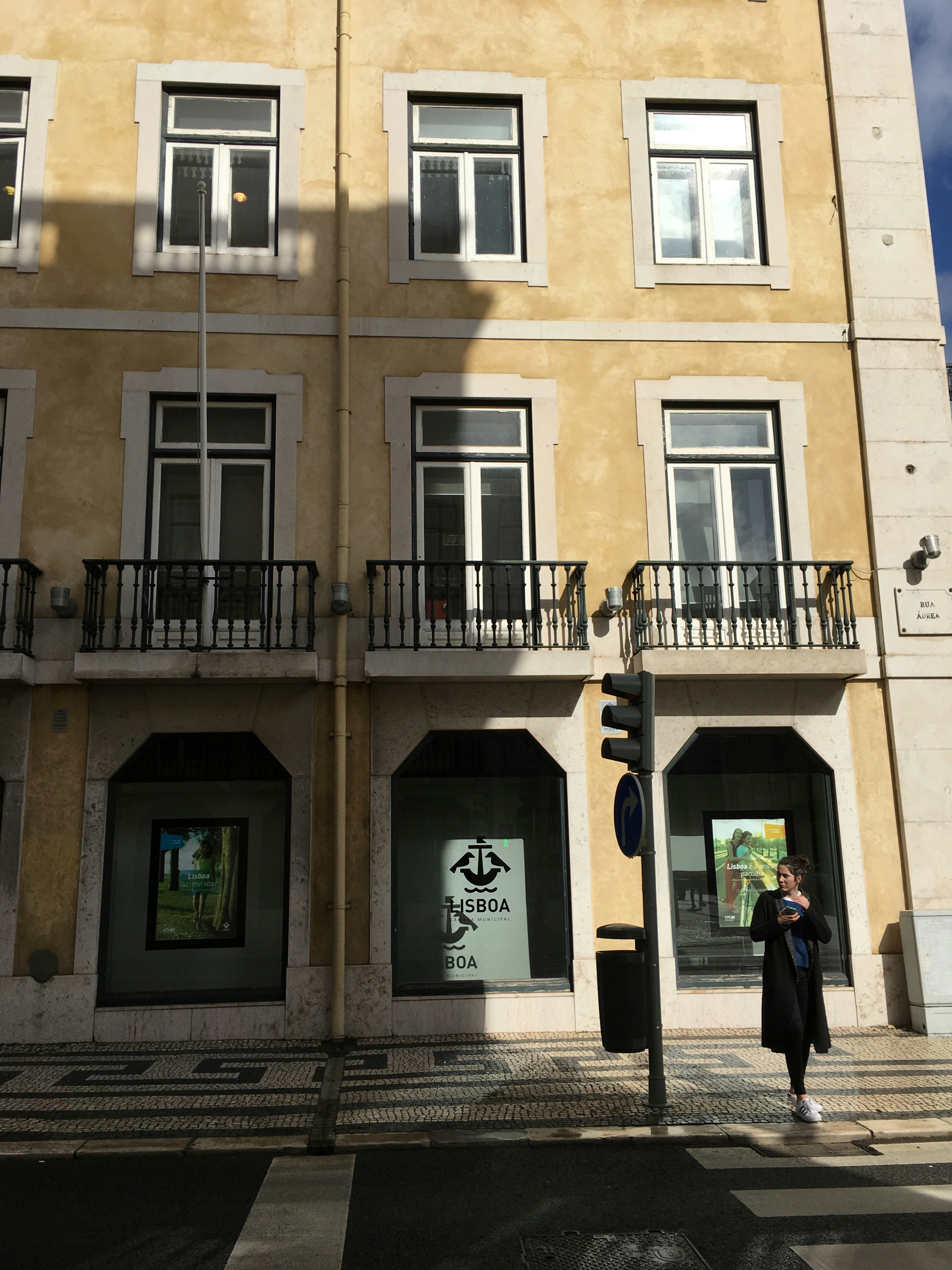 street view of a building facade with windows and a streetlamp