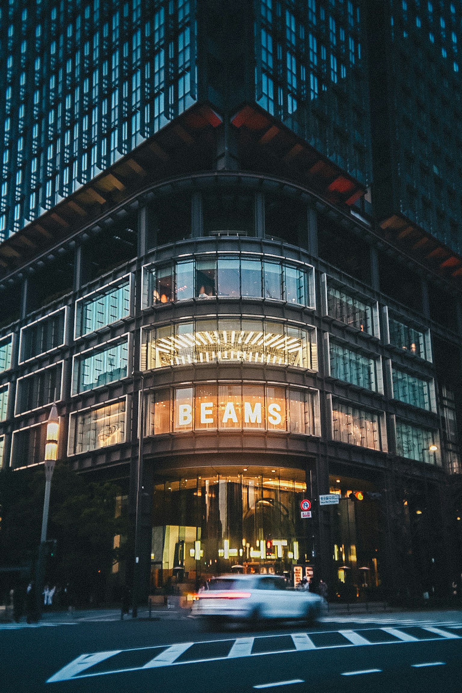 现代建筑外观，BEAMS商店在夜间照明，城市灯光反射