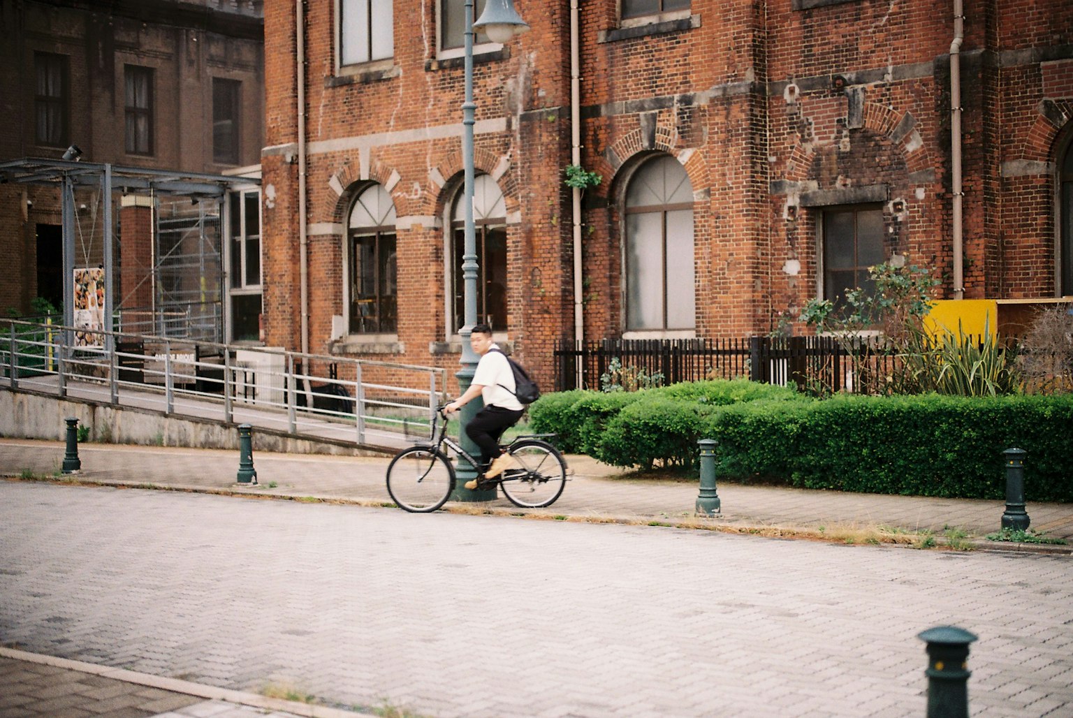 Personne faisant du vélo devant un bâtiment en briques rouges