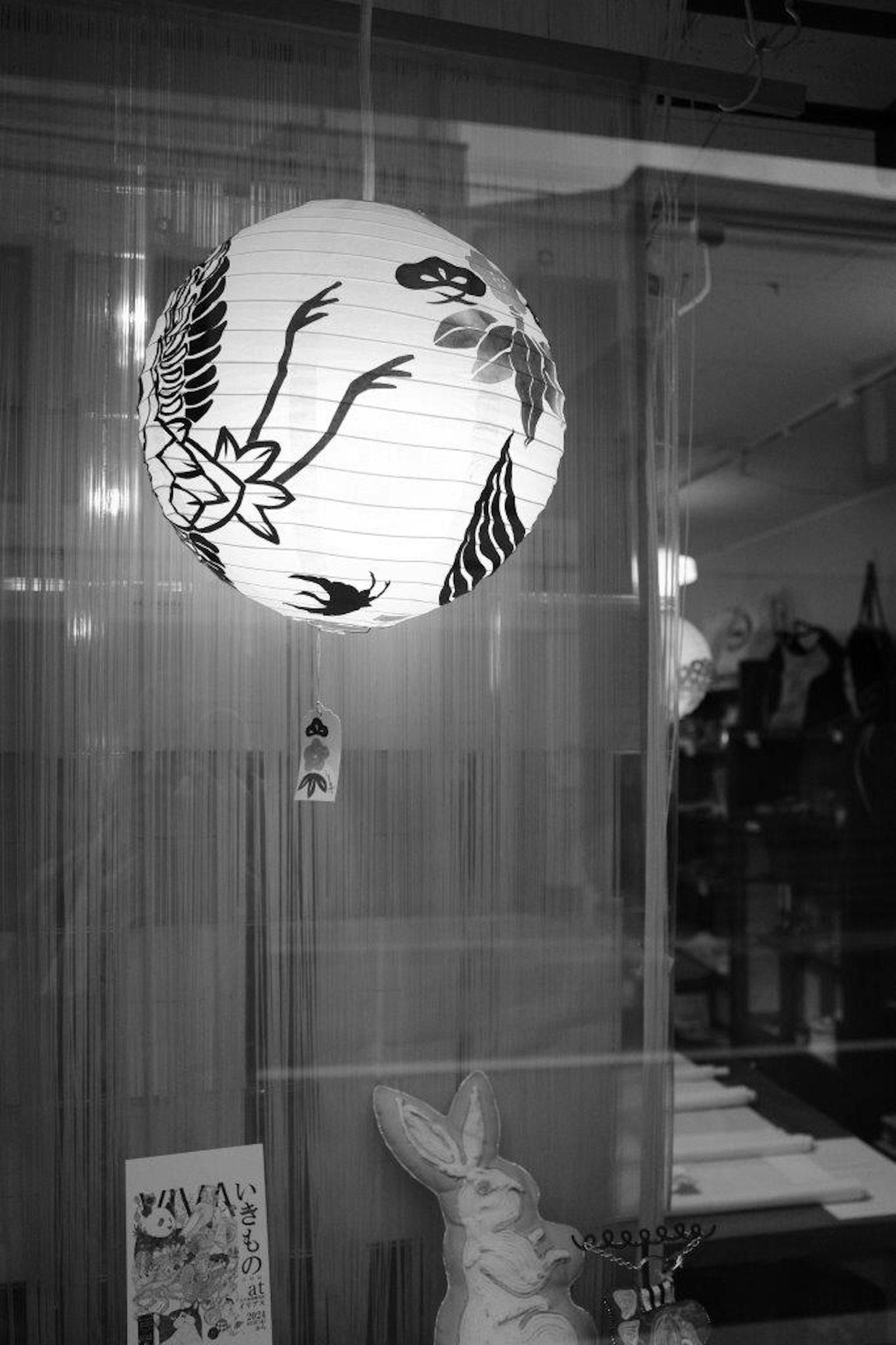 A black and white lantern hanging in a storefront