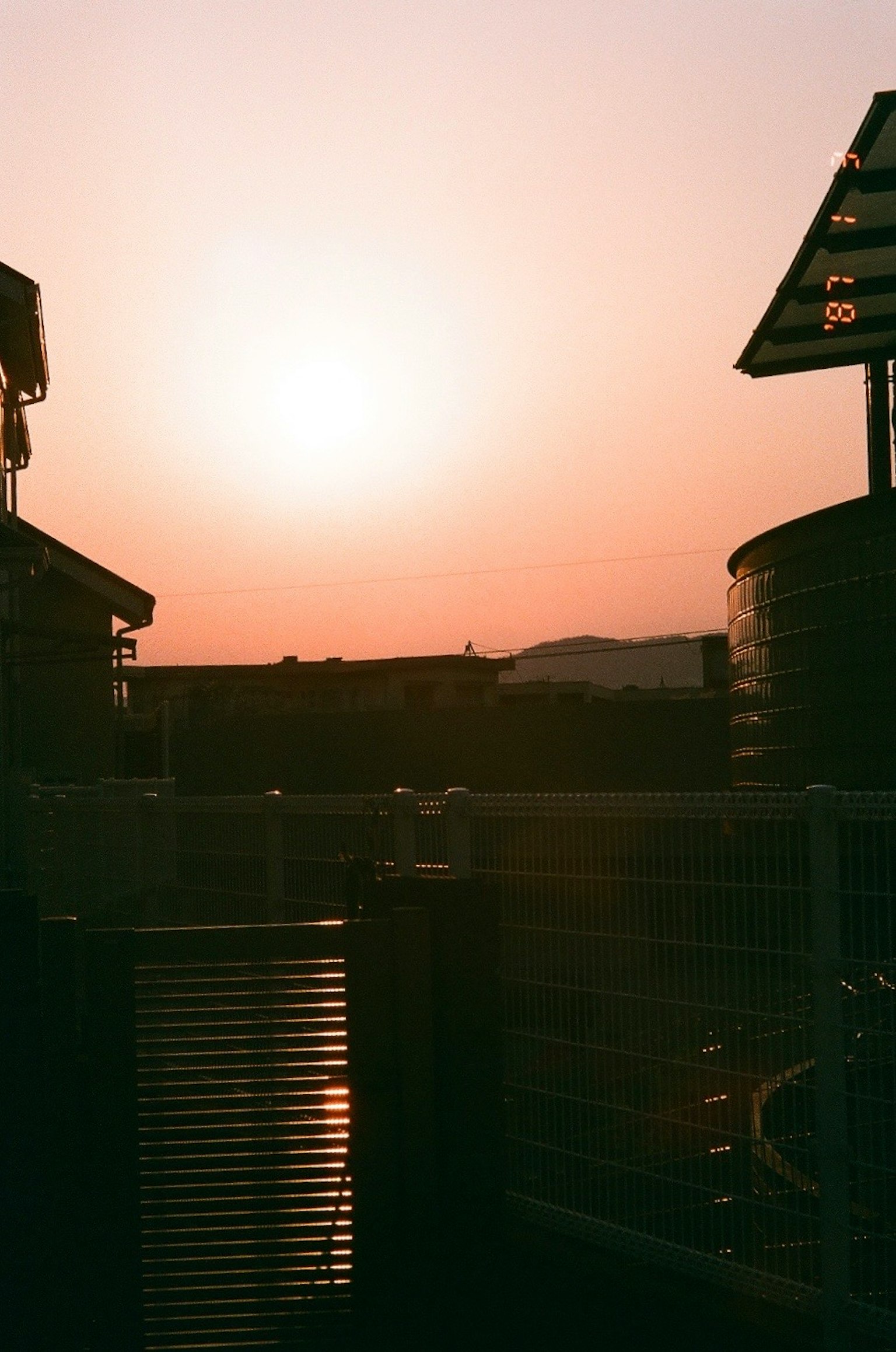 Silhouette of buildings against a sunset sky