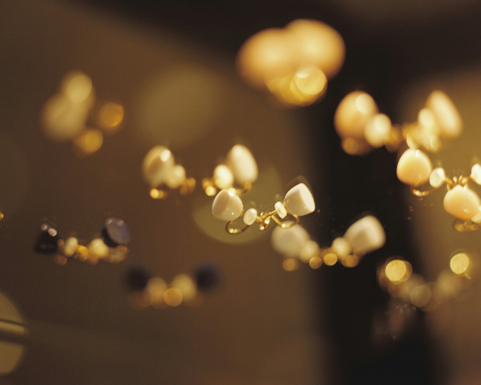 Eine Ausstellung von dekorativen Gegenständen, die wie Edelsteine aussehen und vor einem goldenen Hintergrund schweben