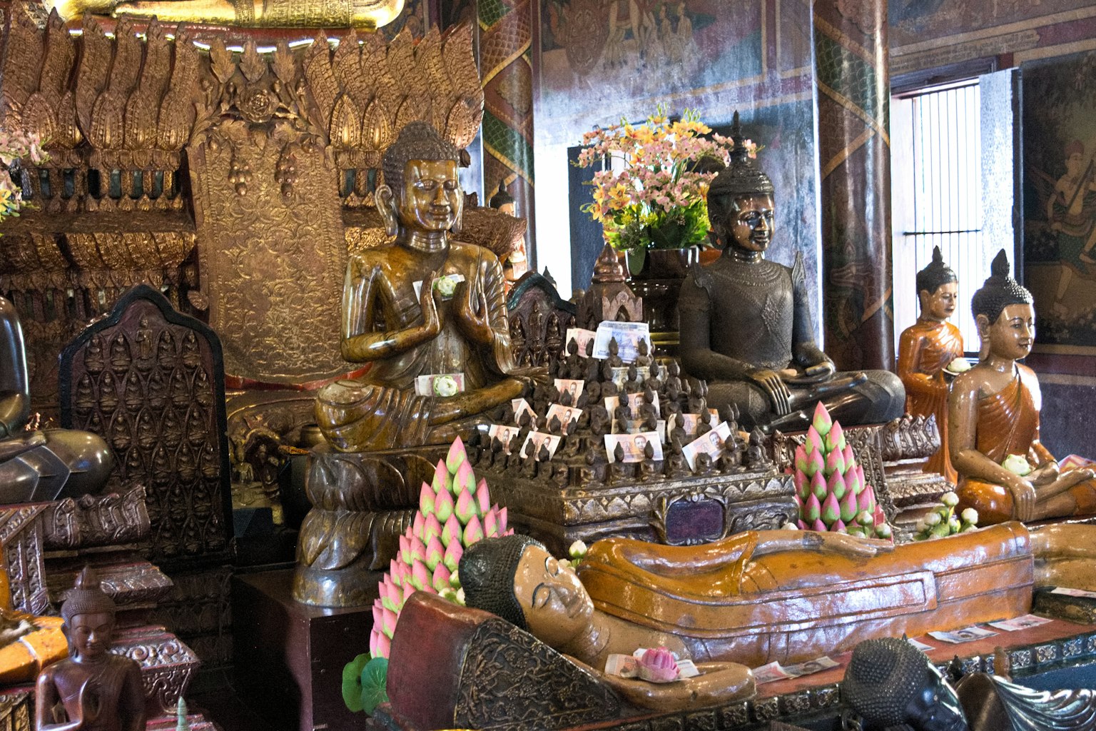 Interior de un templo con múltiples estatuas de Buda y decoraciones intrincadas