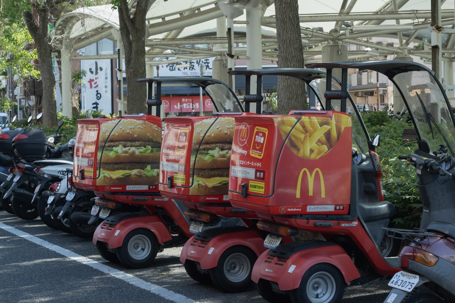 Rote Lieferfahrzeuge mit McDonald's Branding in einer Reihe geparkt