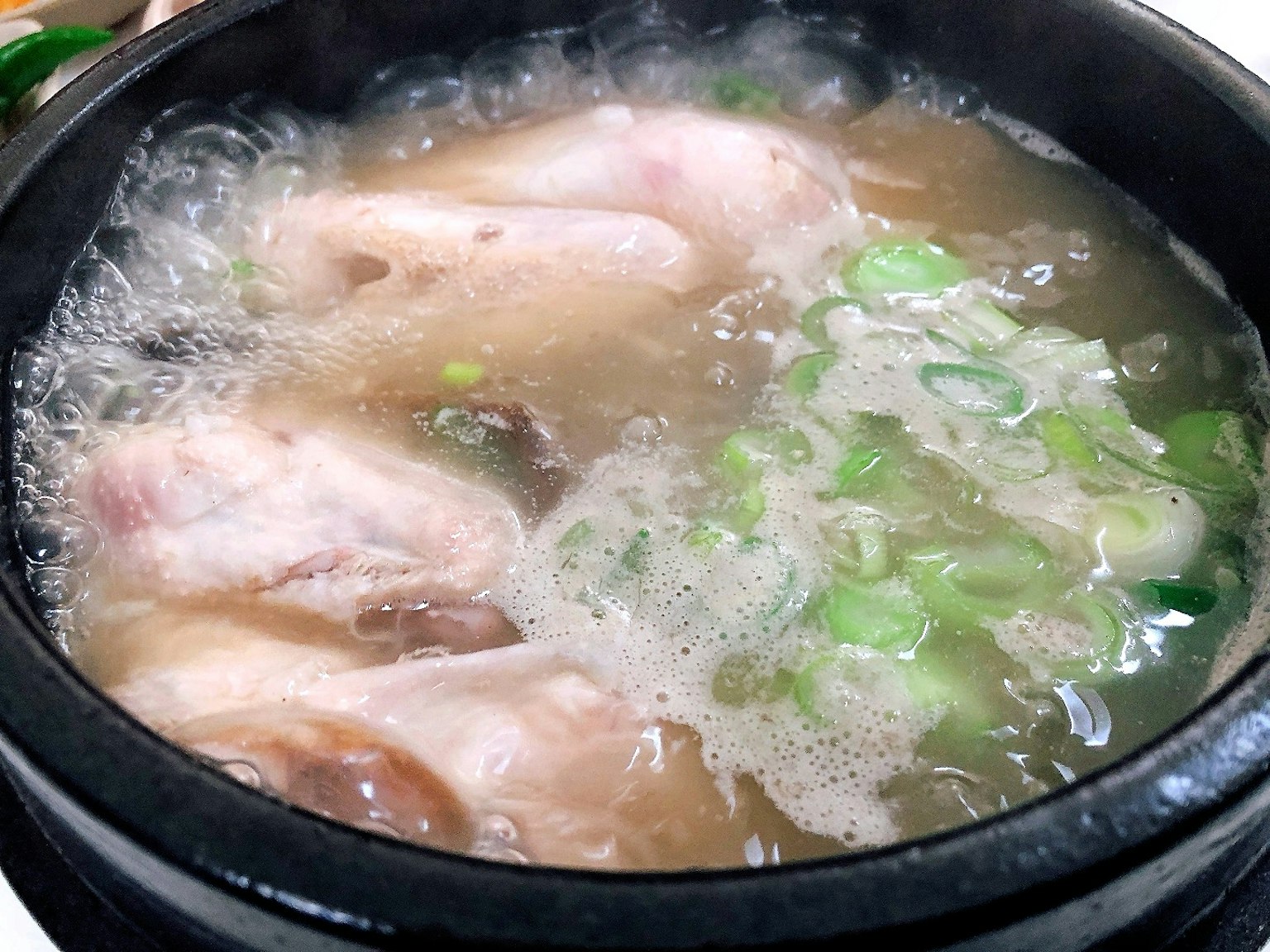 Ein Topf Suppe mit Hähnchen und Frühlingszwiebeln