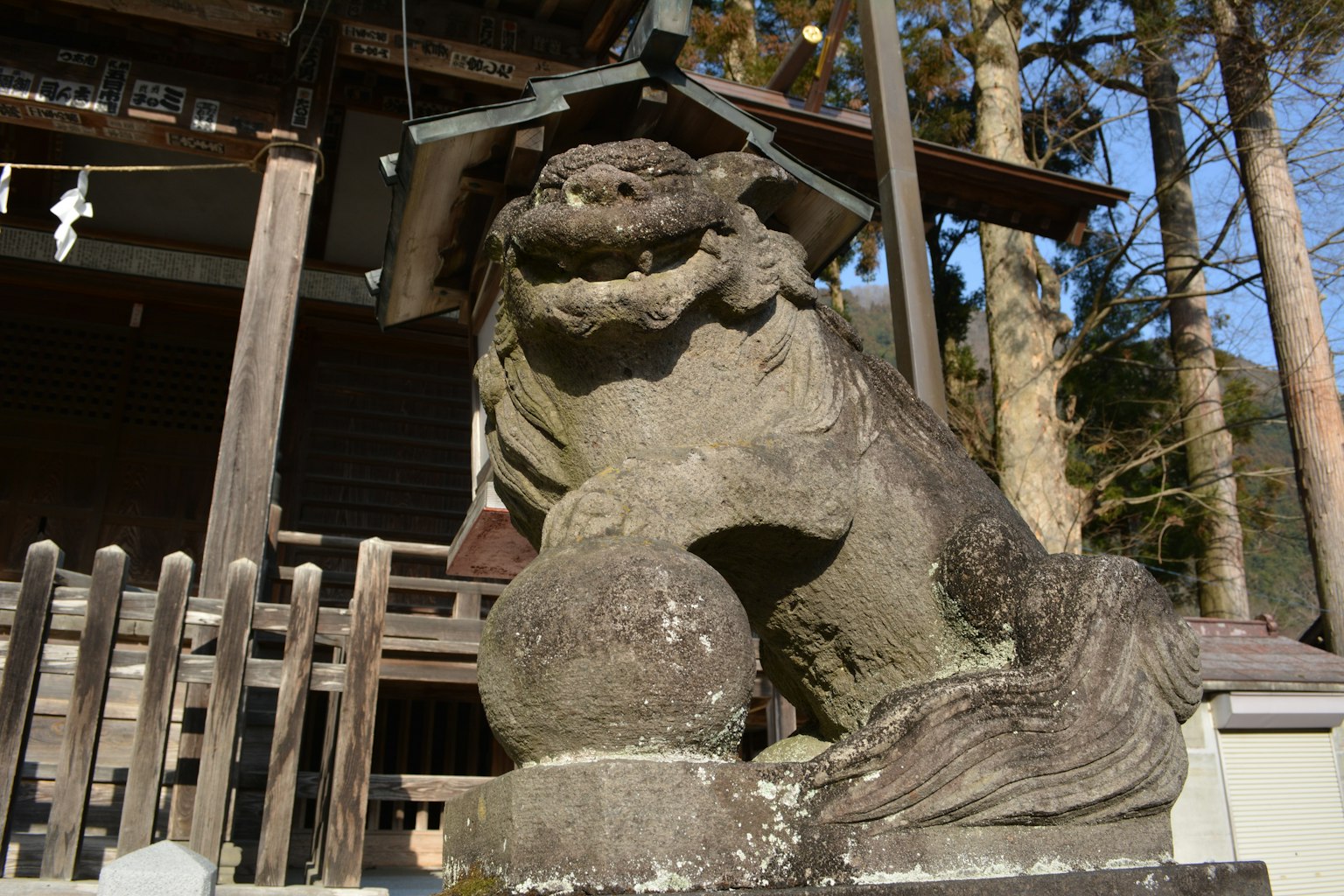 Stone komainu holding a ball at a shrine