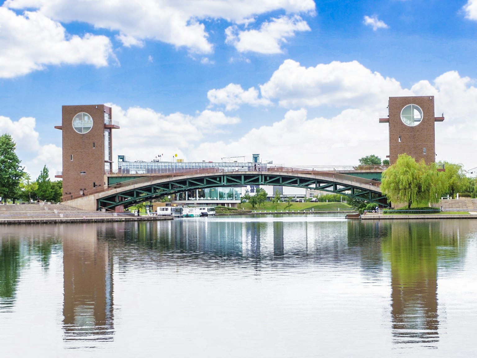 Puente con torres de reloj sobre un río tranquilo bajo un cielo azul