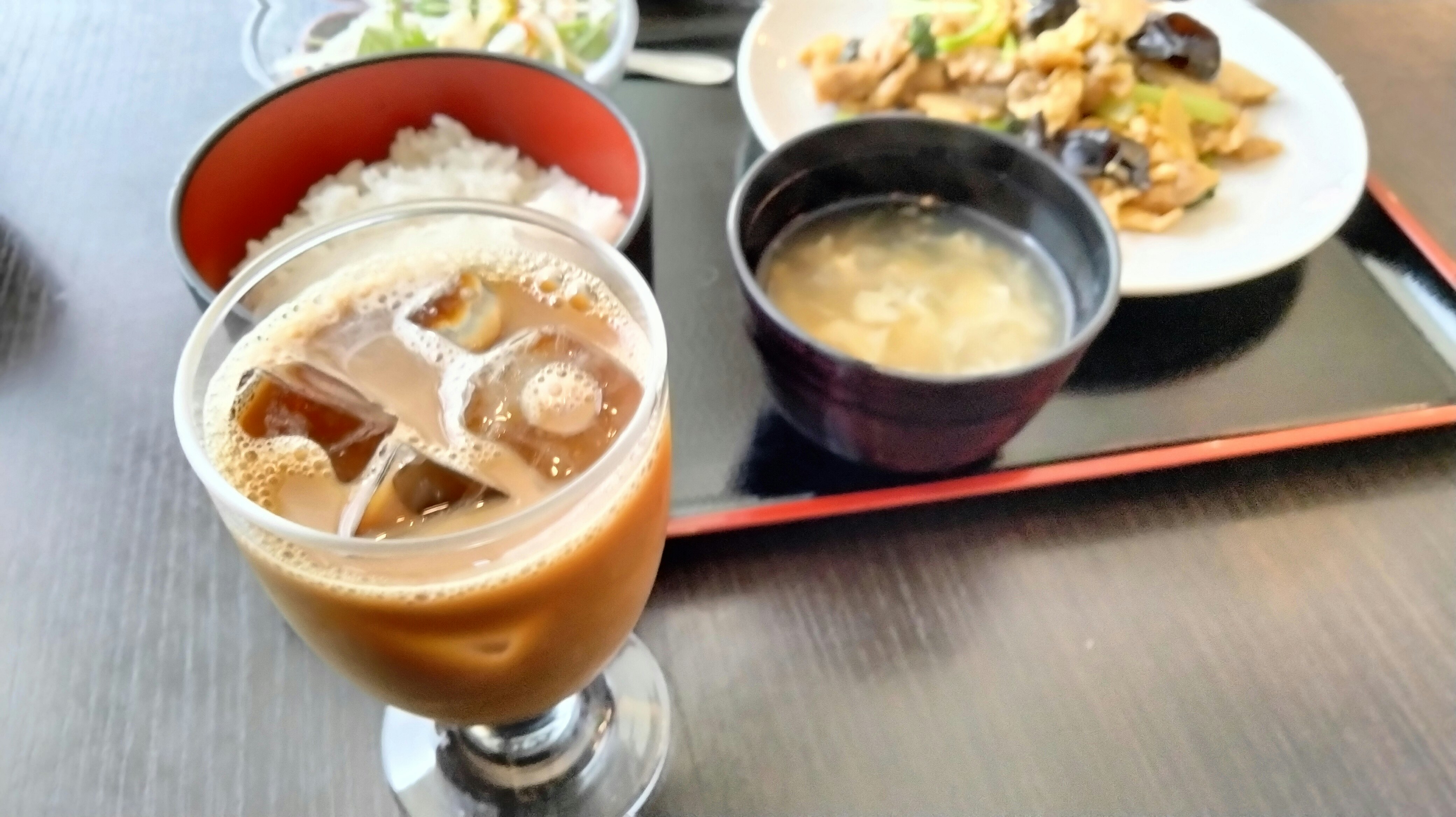 グラスに注がれた飲み物と味噌汁、焼き物の食卓