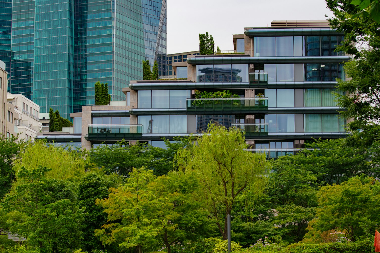 Modern building complex surrounded by greenery with skyscrapers in the background