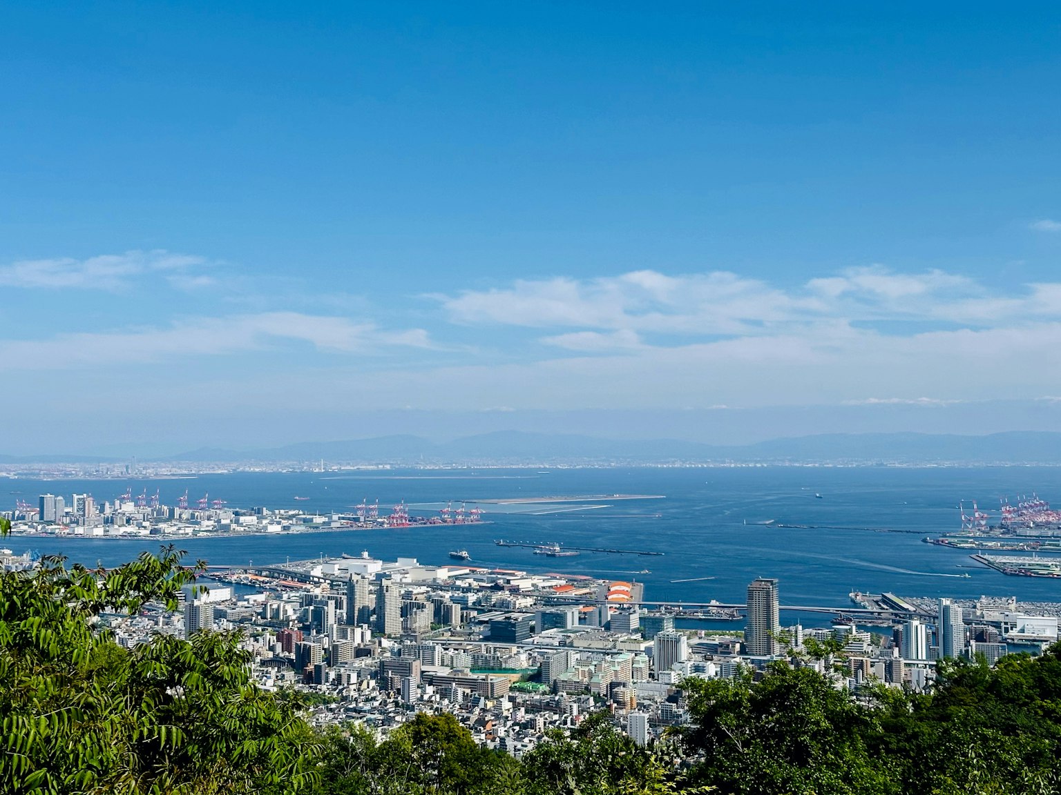 Panoramablick auf eine Stadt mit blauem Himmel und Meer im Hintergrund