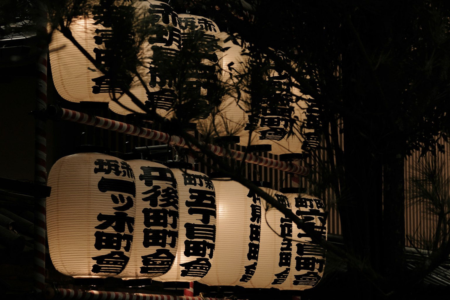 在黑暗背景下照亮的日本街燈標誌，顯示漢字地名