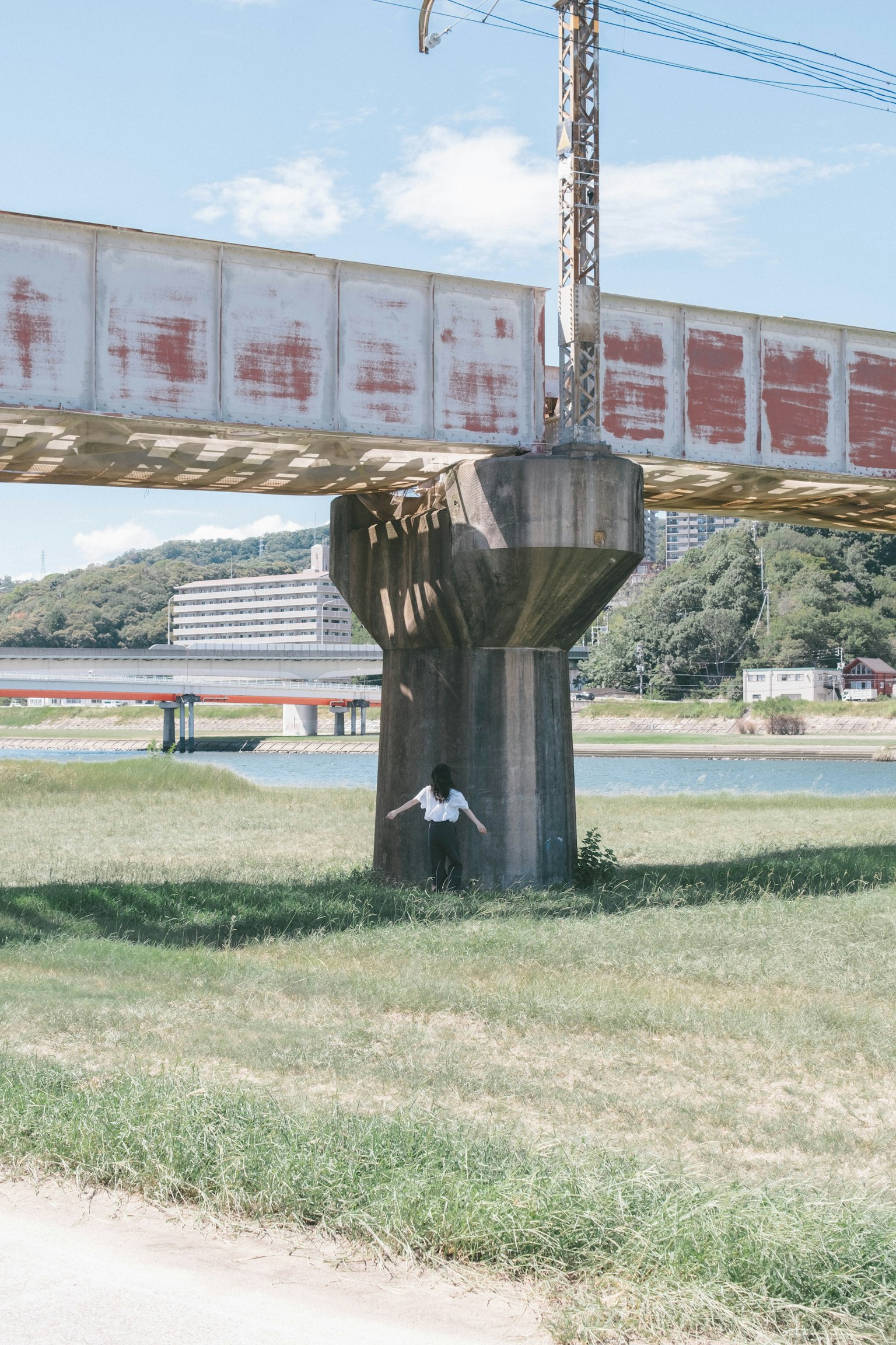 Un soporte de puente ferroviario cerca de un río con área de césped