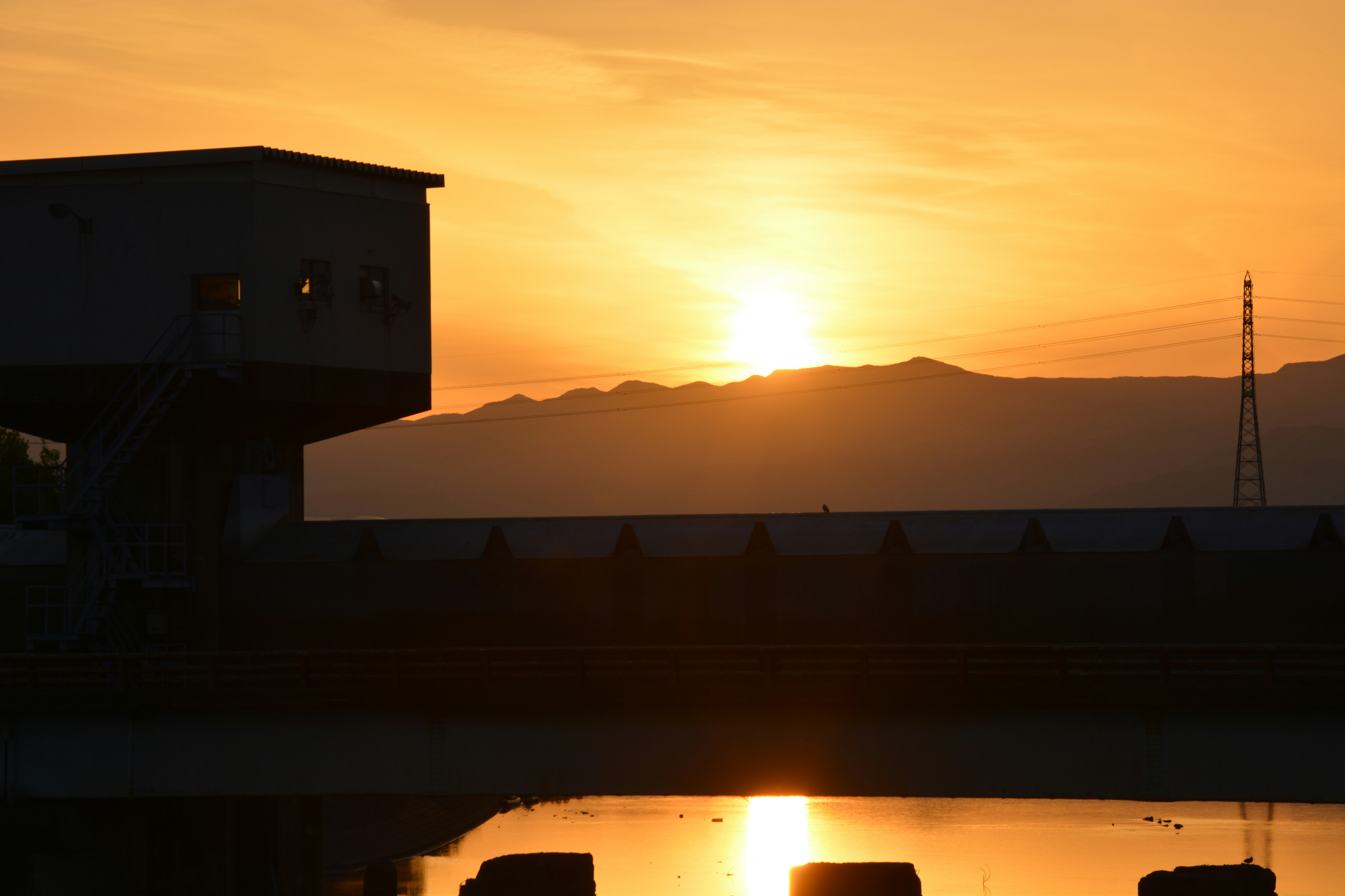 夕日に照らされた山並みと水面の反射