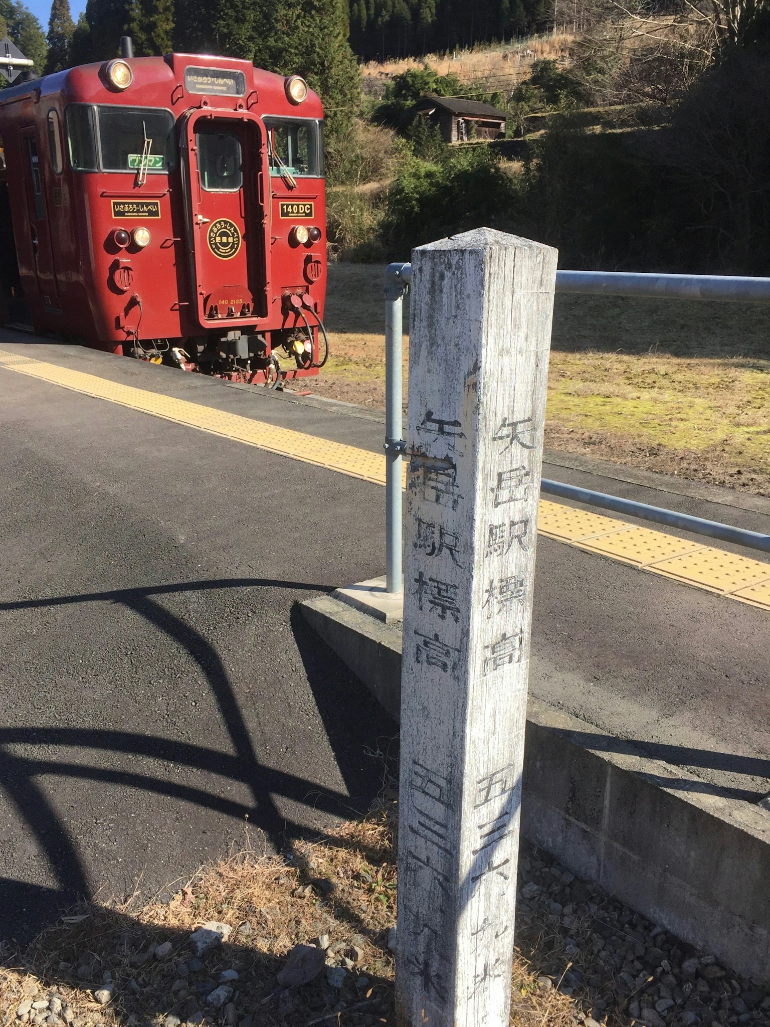 車站停靠的紅色列車和前景的標誌牌