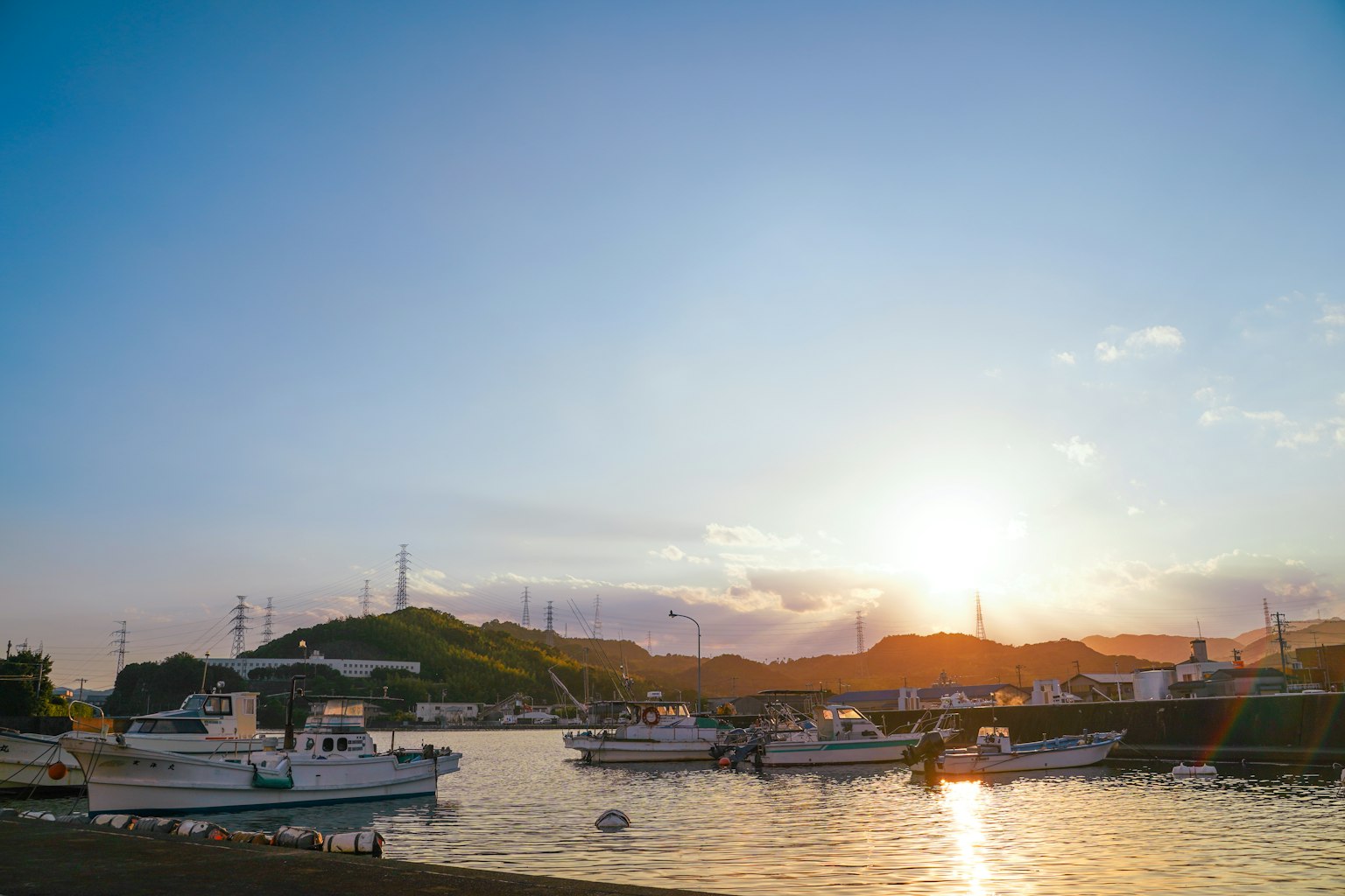 Fishing boats on a tranquil harbor at sunset