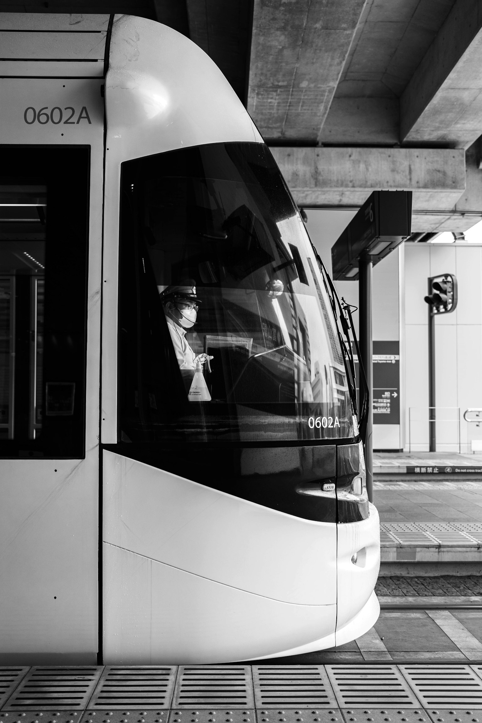 Vista laterale di un tram in bianco e nero in una stazione