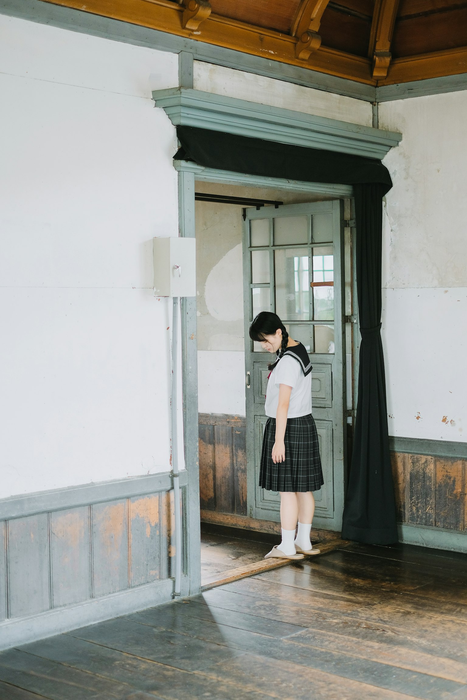 Một cô gái đứng trước cửa trong một căn phòng