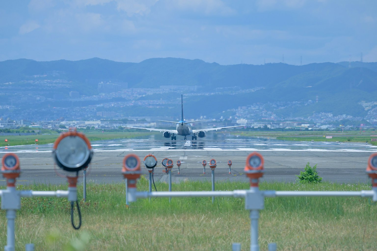 Avion sur la piste avec des équipements d'éclairage d'aéroport au premier plan