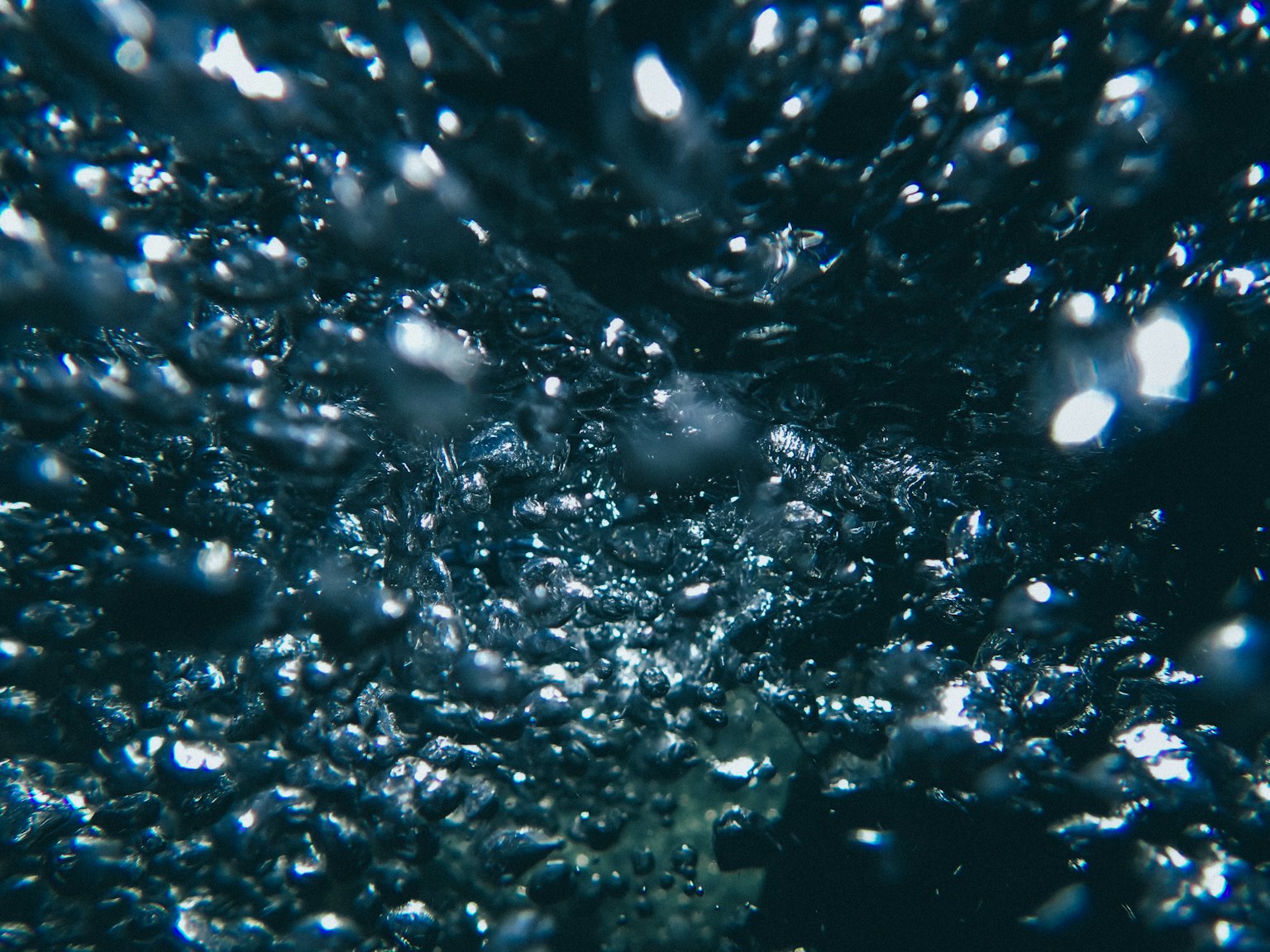 Une image de bulles montant dans l'eau sombre