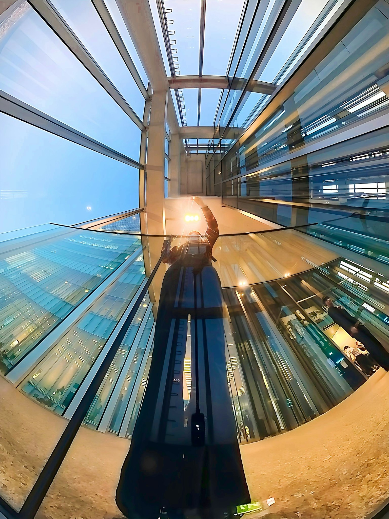 Una persona che proietta la propria ombra all'interno di un edificio in vetro