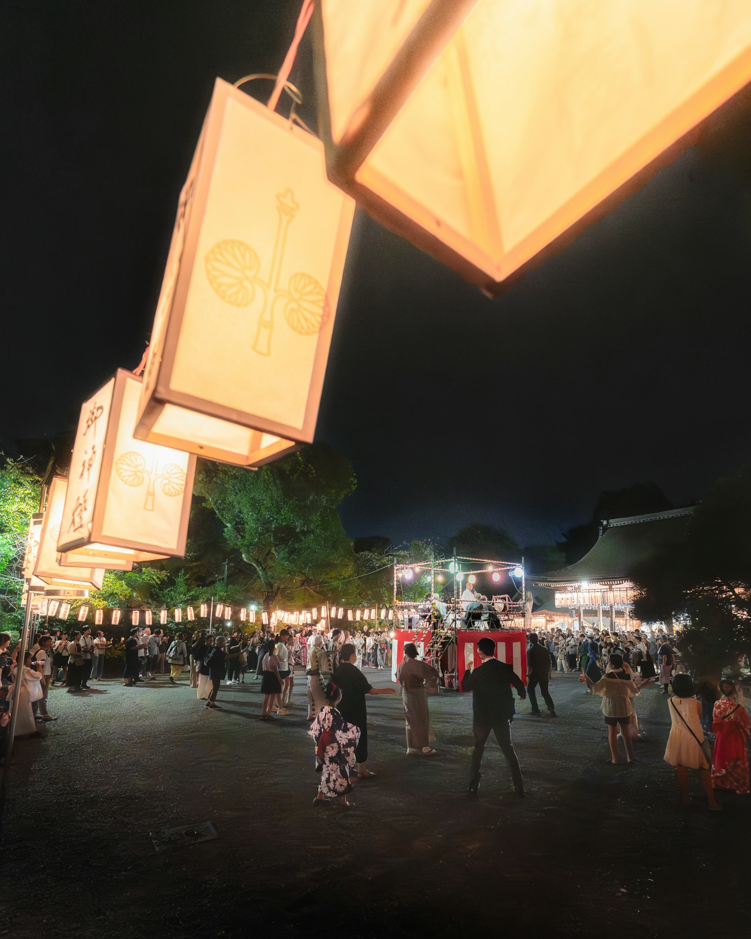 Festival notturno con lanterne appese e folle di persone