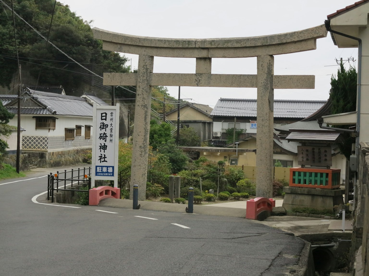 Steinerner Torii-Bogen am Eingang eines japanischen Schreins mit umliegender Landschaft