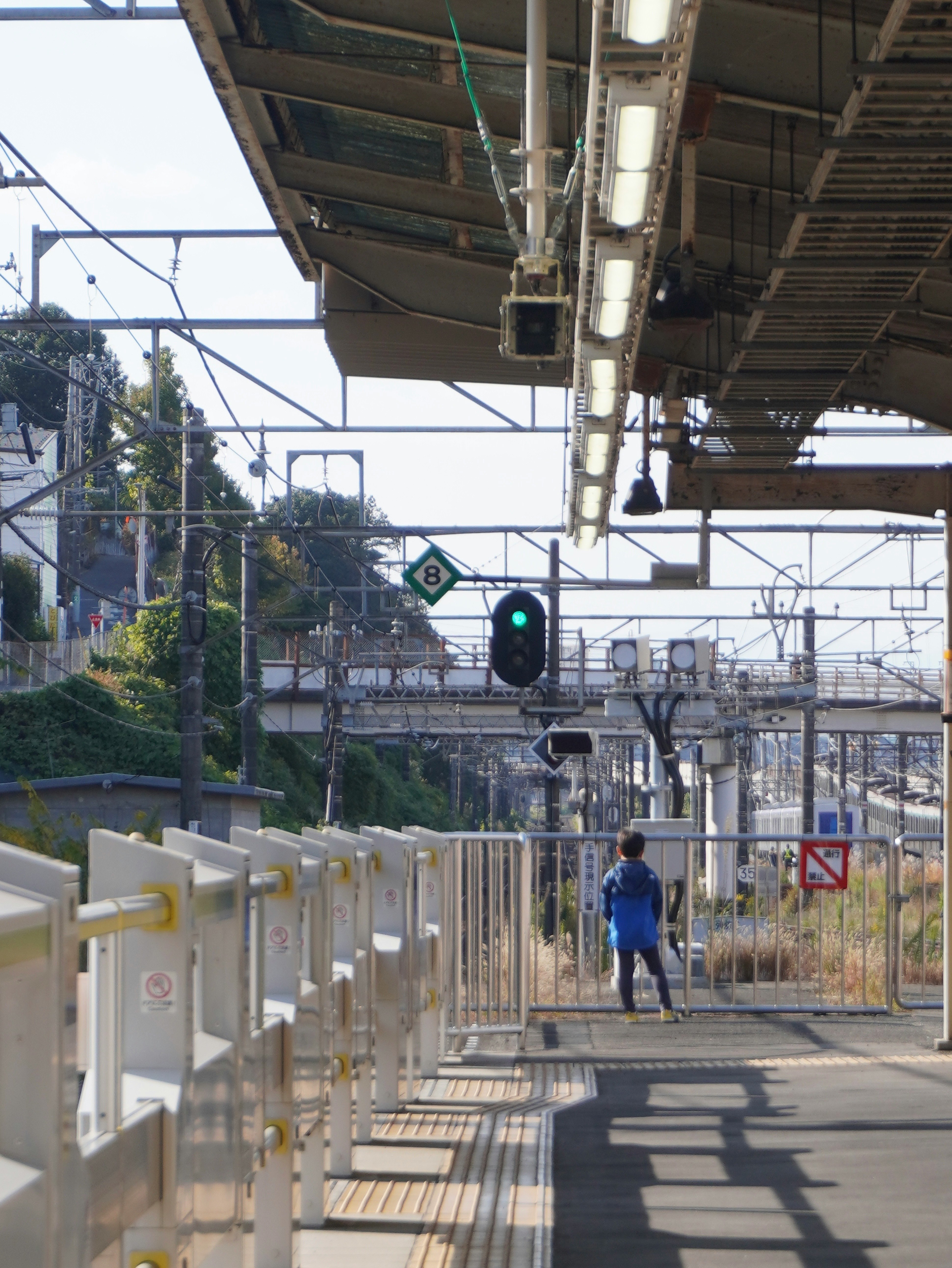 駅のホームを歩く少年