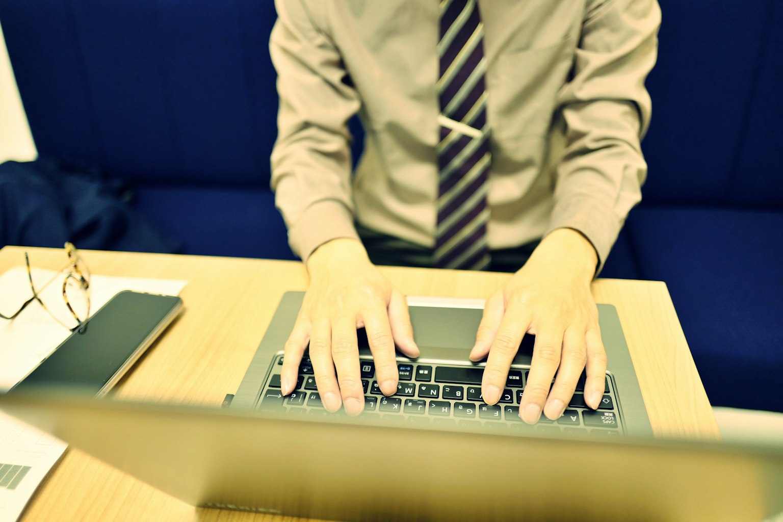 Geschäftsmann tippt auf einem Laptop in einer professionellen Umgebung