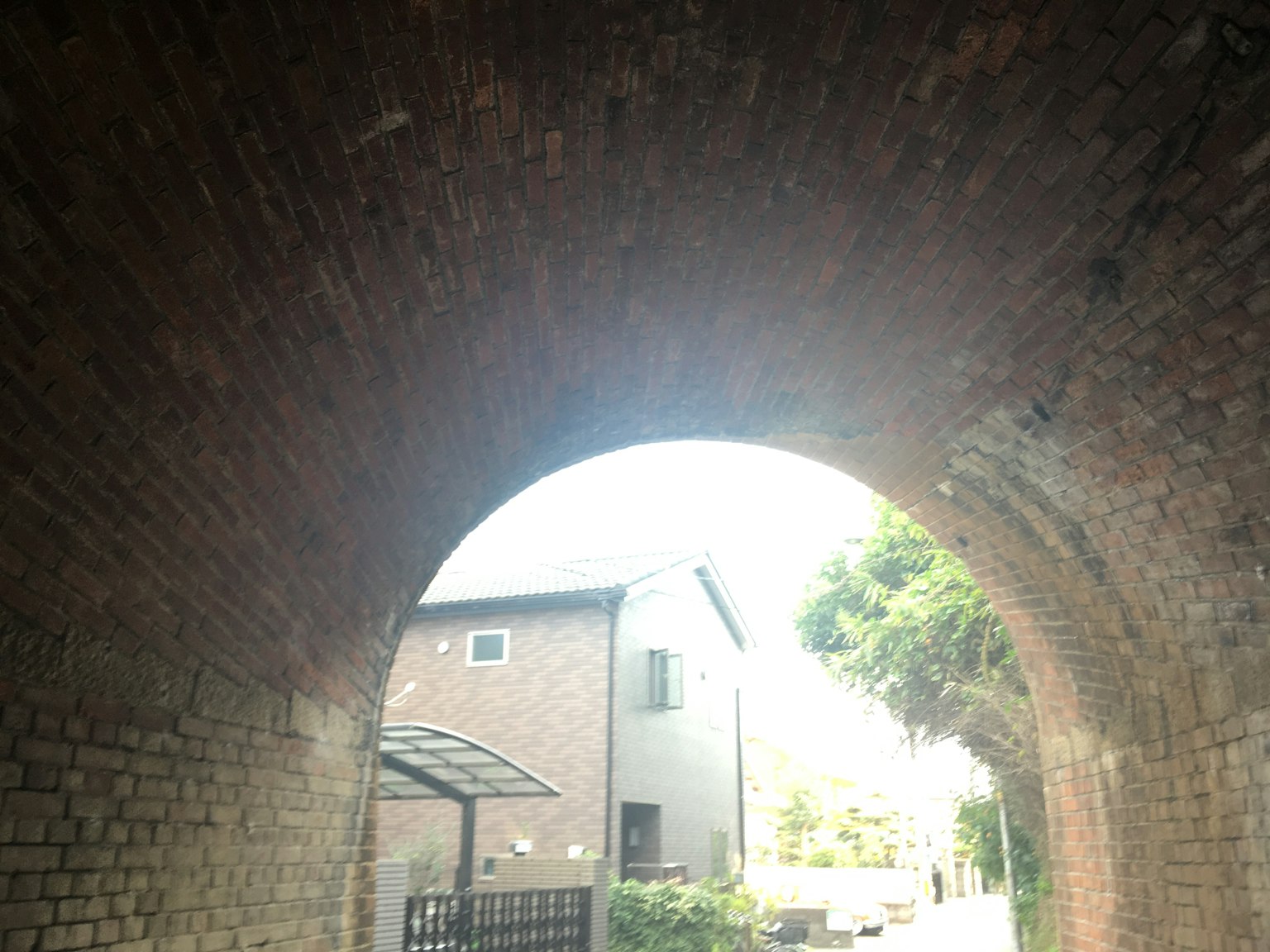 Ziegelbogen mit Lichtdurchlässigkeit und umliegenden Häusern