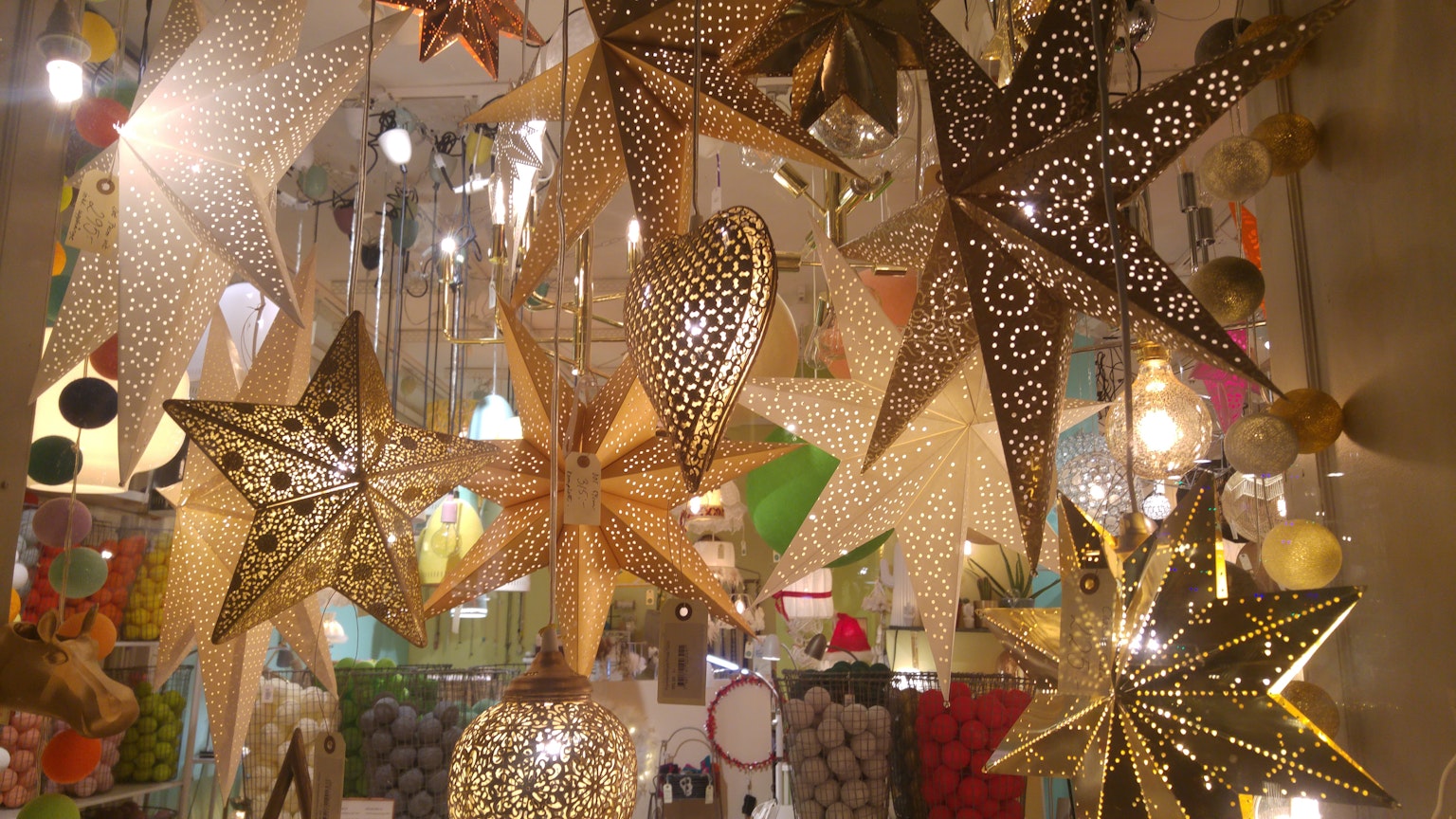 Lámparas decorativas en forma de estrella de colores colgando en un espacio brillante